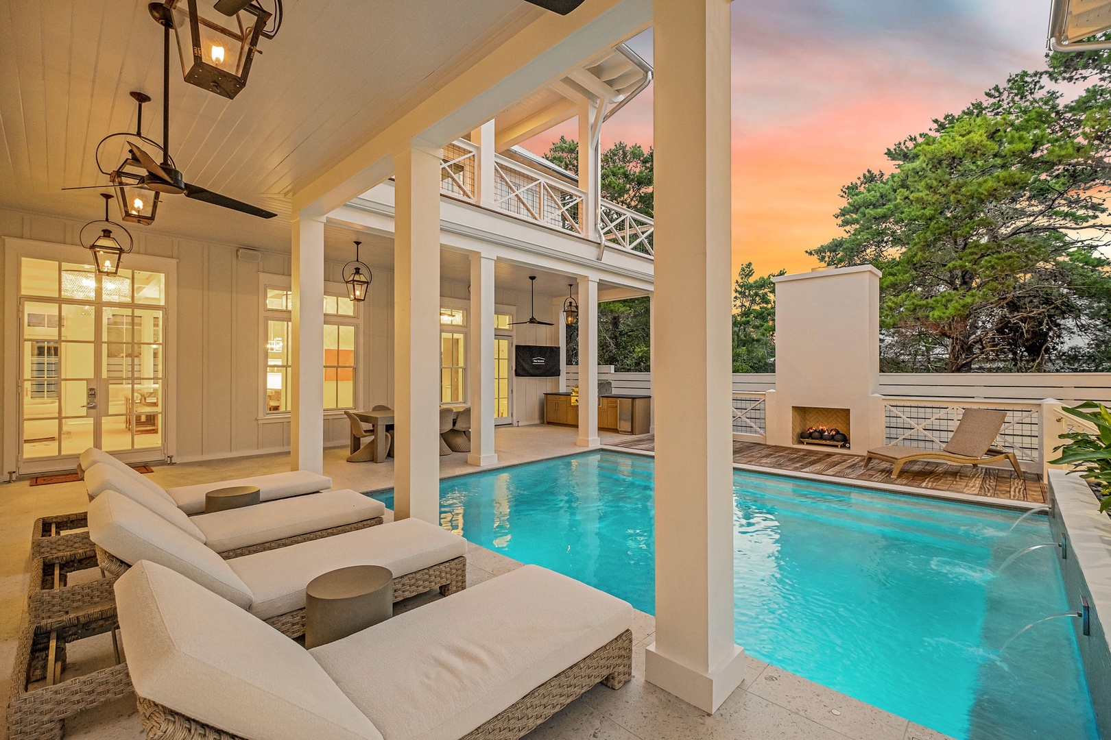 Unwind on plush poolside loungers beneath charming lantern lighting as the sunset paints the sky in soft pastel hues, your private oasis awaits.