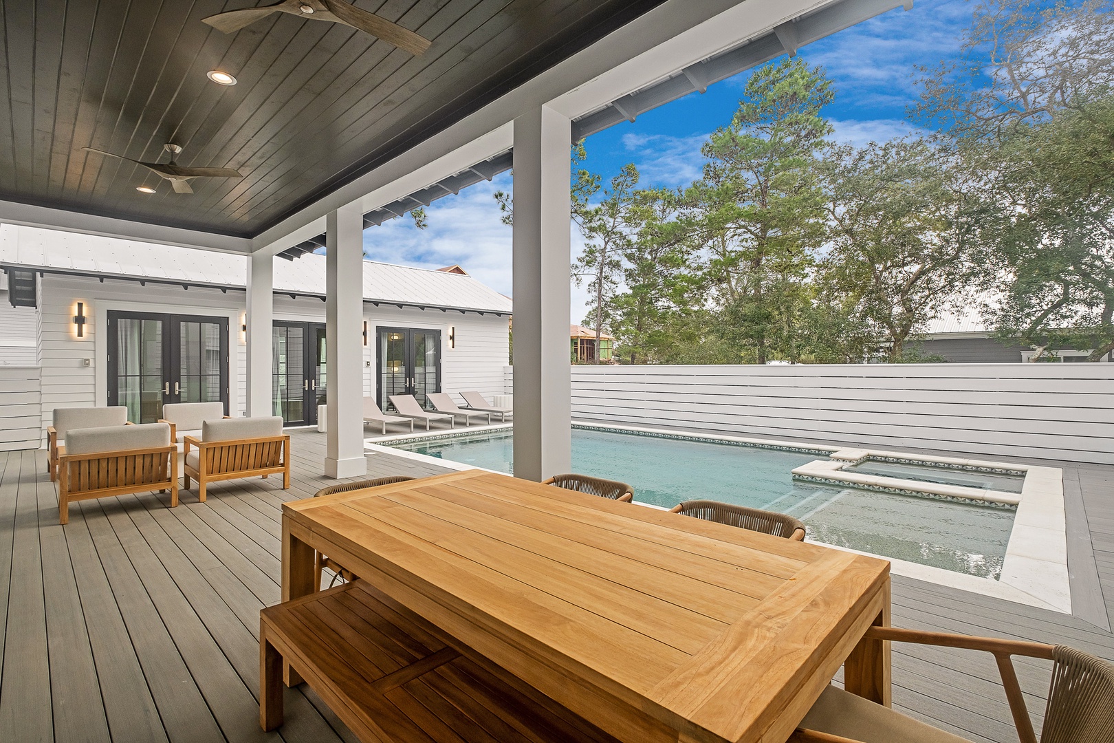 Your private covered patio invites relaxation with teak dining and lounge furniture overlooking the sparkling pool.