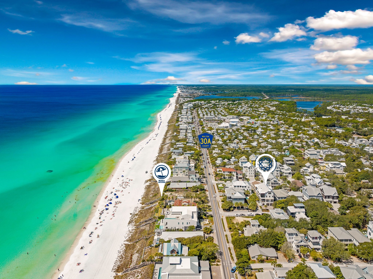 Aerial view of pristine emerald coastline with white sand beach stretching along residential neighborhoods near Highway 30A.