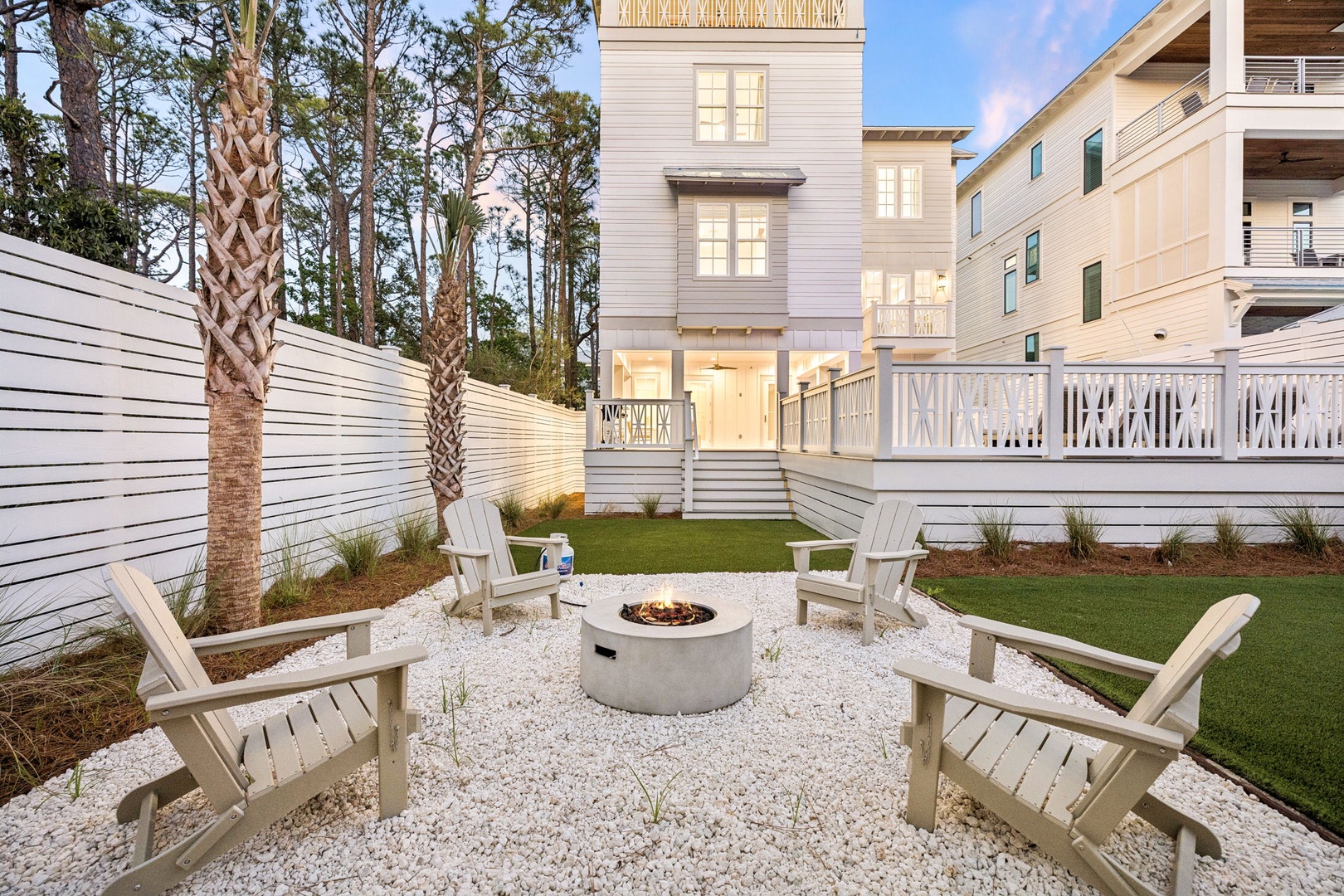 Gather around your private fire pit for cozy evenings under the stars, surrounded by comfortable Adirondack chairs in this peaceful backyard retreat.
