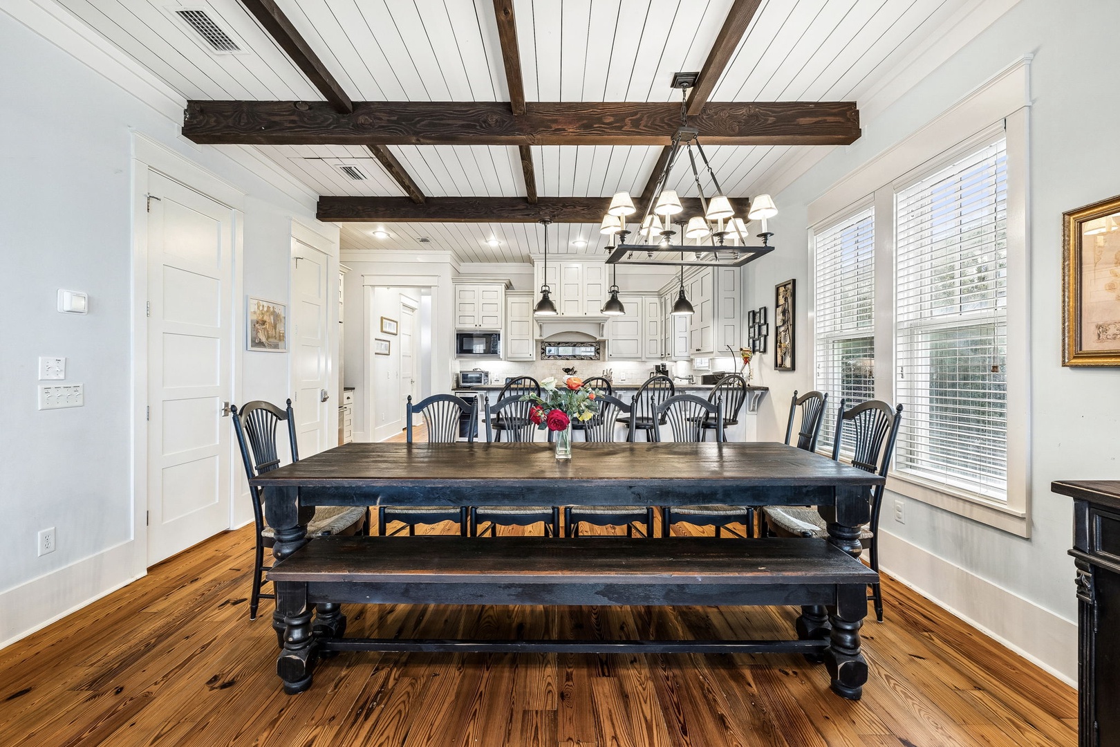 Gather around this spacious farmhouse dining table where rustic wood beams and bright natural light create the perfect setting for your group meals and memorable conversations.