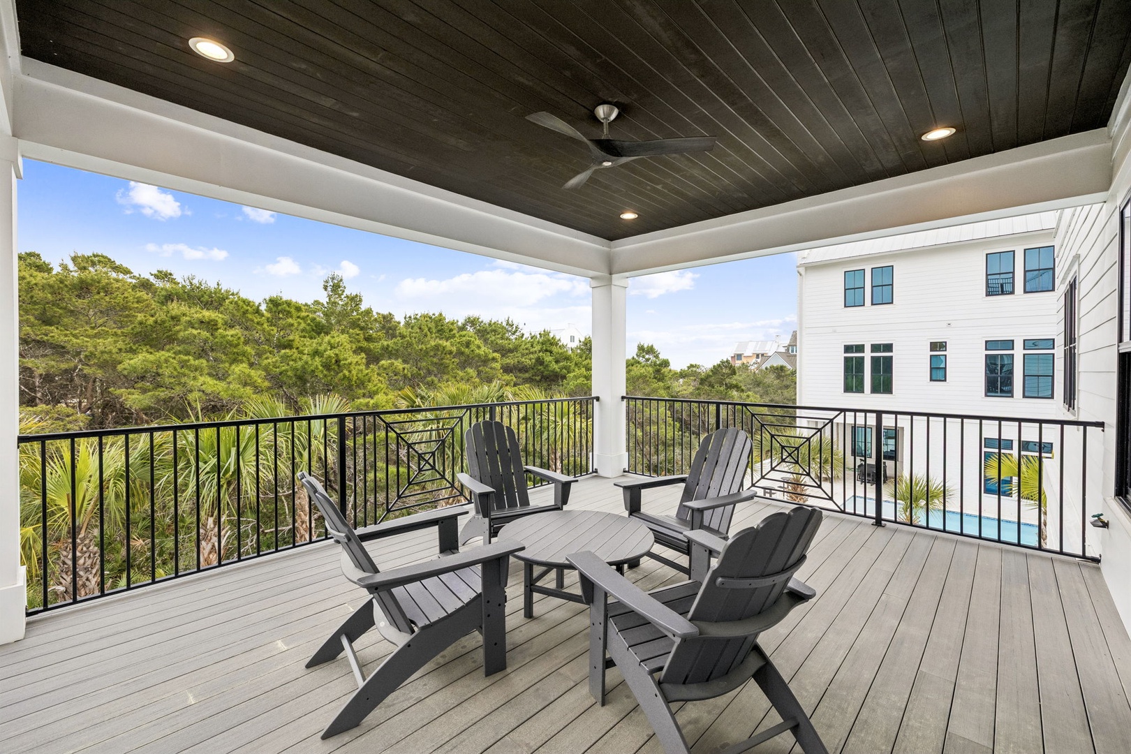 Relax on your private covered terrace with Adirondack chairs and poolside views, perfect for morning coffee or evening conversations.