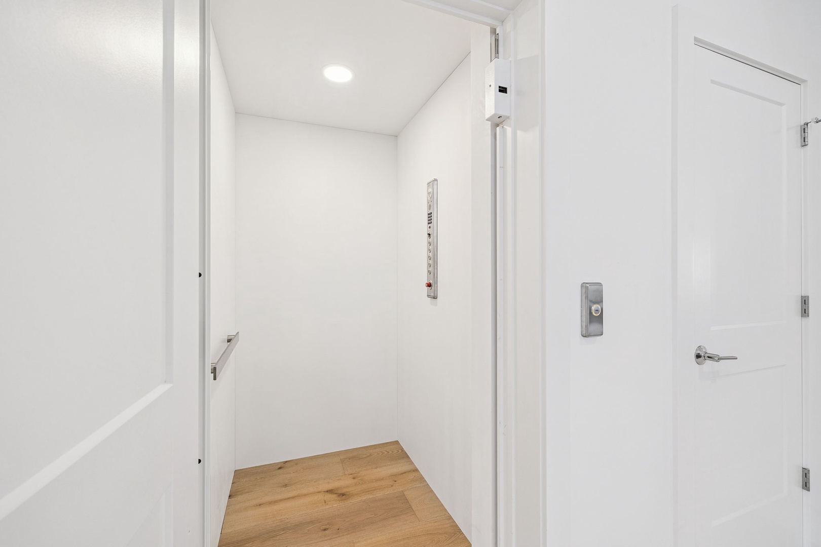 Step into your bright, modern entryway with warm wood floors and clean white walls that welcome you home.