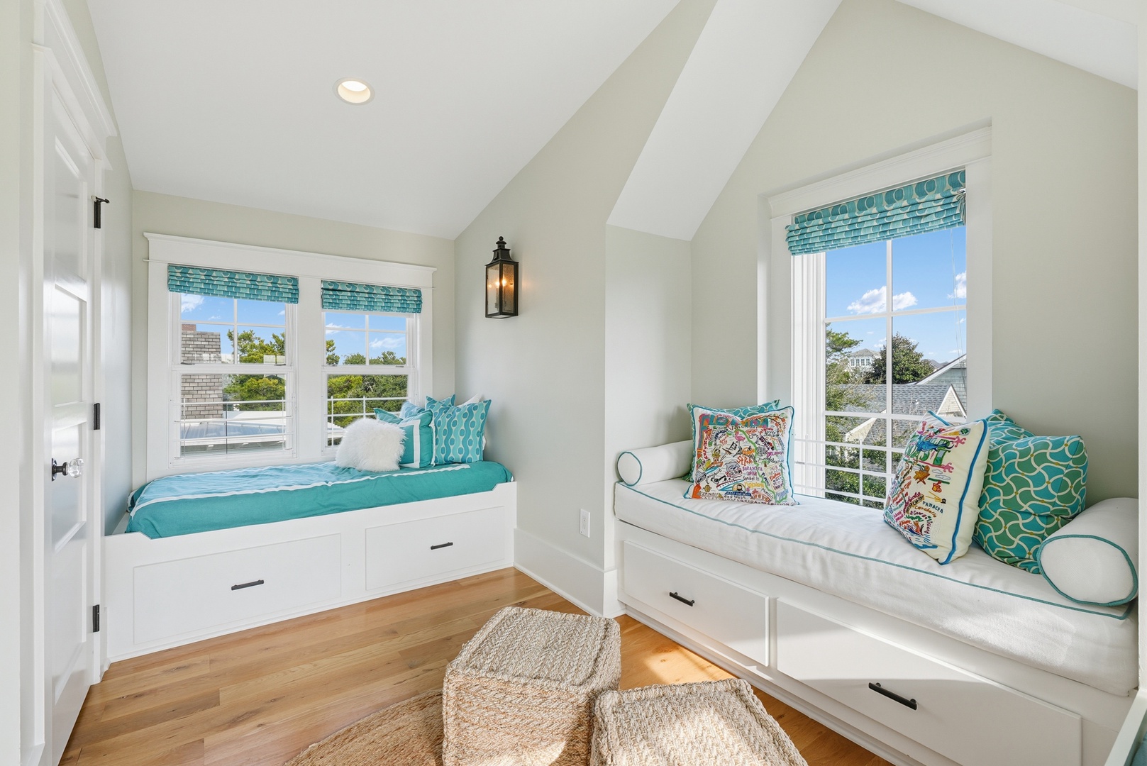 Curl up in your cozy window seats with cushions and turquoise accents, where natural light streams in and built-in storage keeps your space tidy and serene.