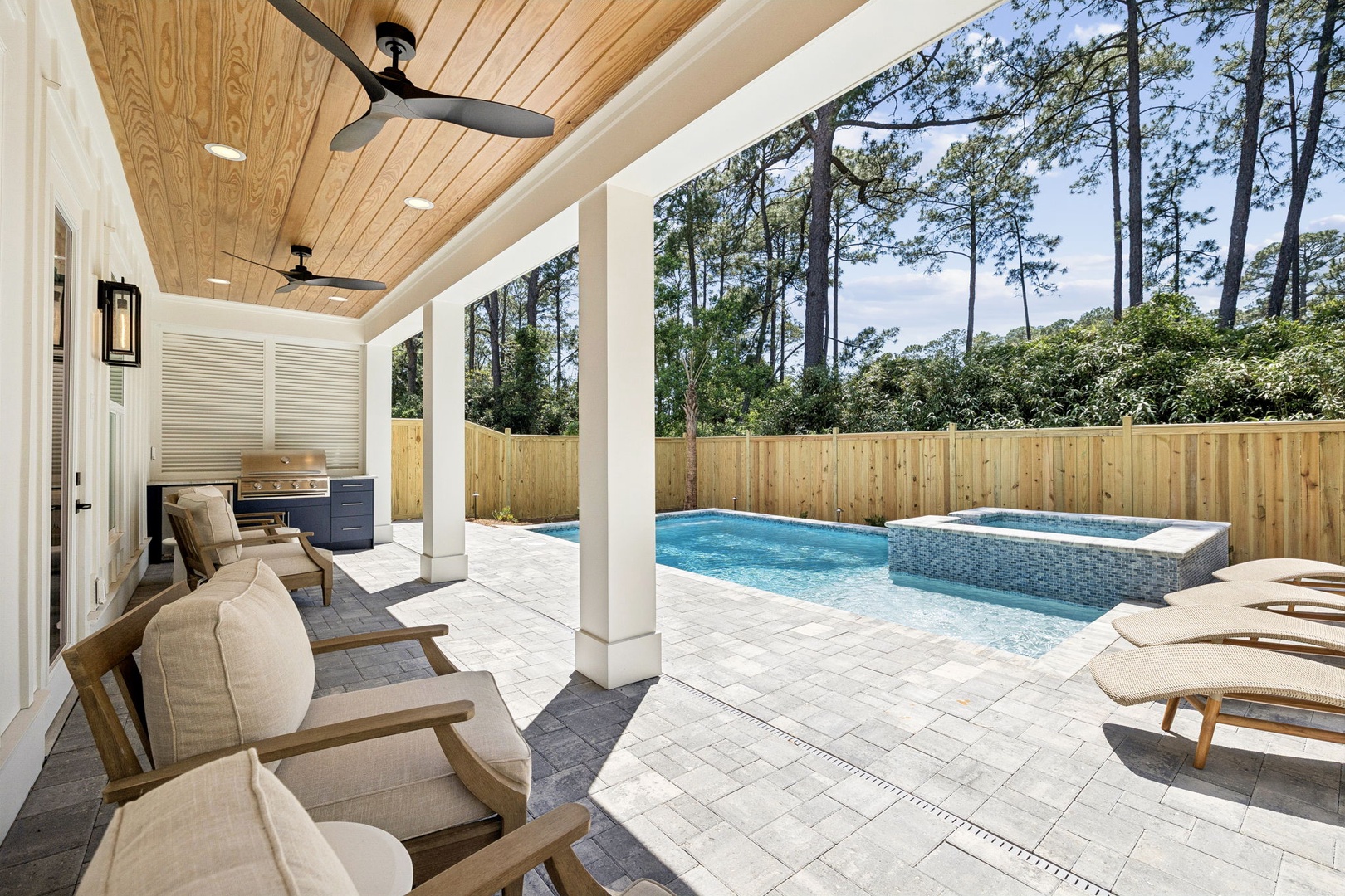 Your private oasis awaits with a sparkling pool, soothing hot tub, and shaded lounging under elegant wood ceilings. Relax poolside or grill your favorite meal in serene, sun-dappled surroundings.