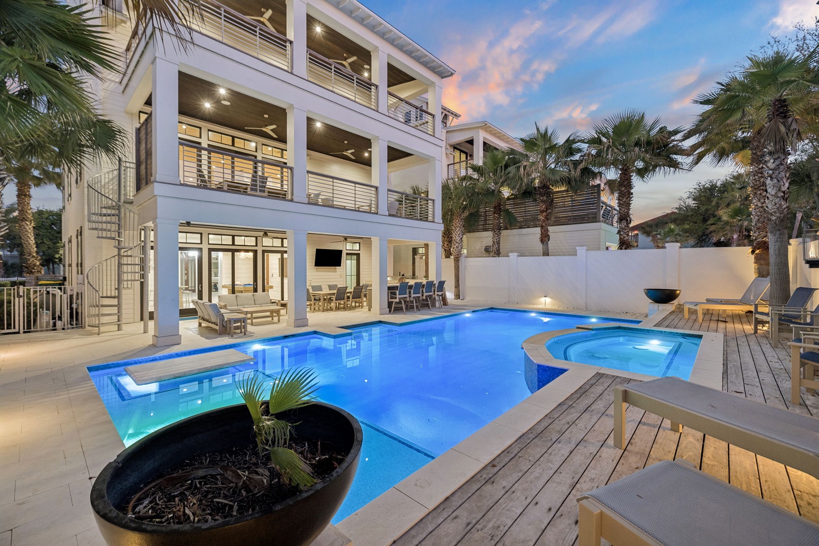 Modern luxury vacation home with private pool and hot tub, surrounded by tropical palms in an elegant waterfront setting.