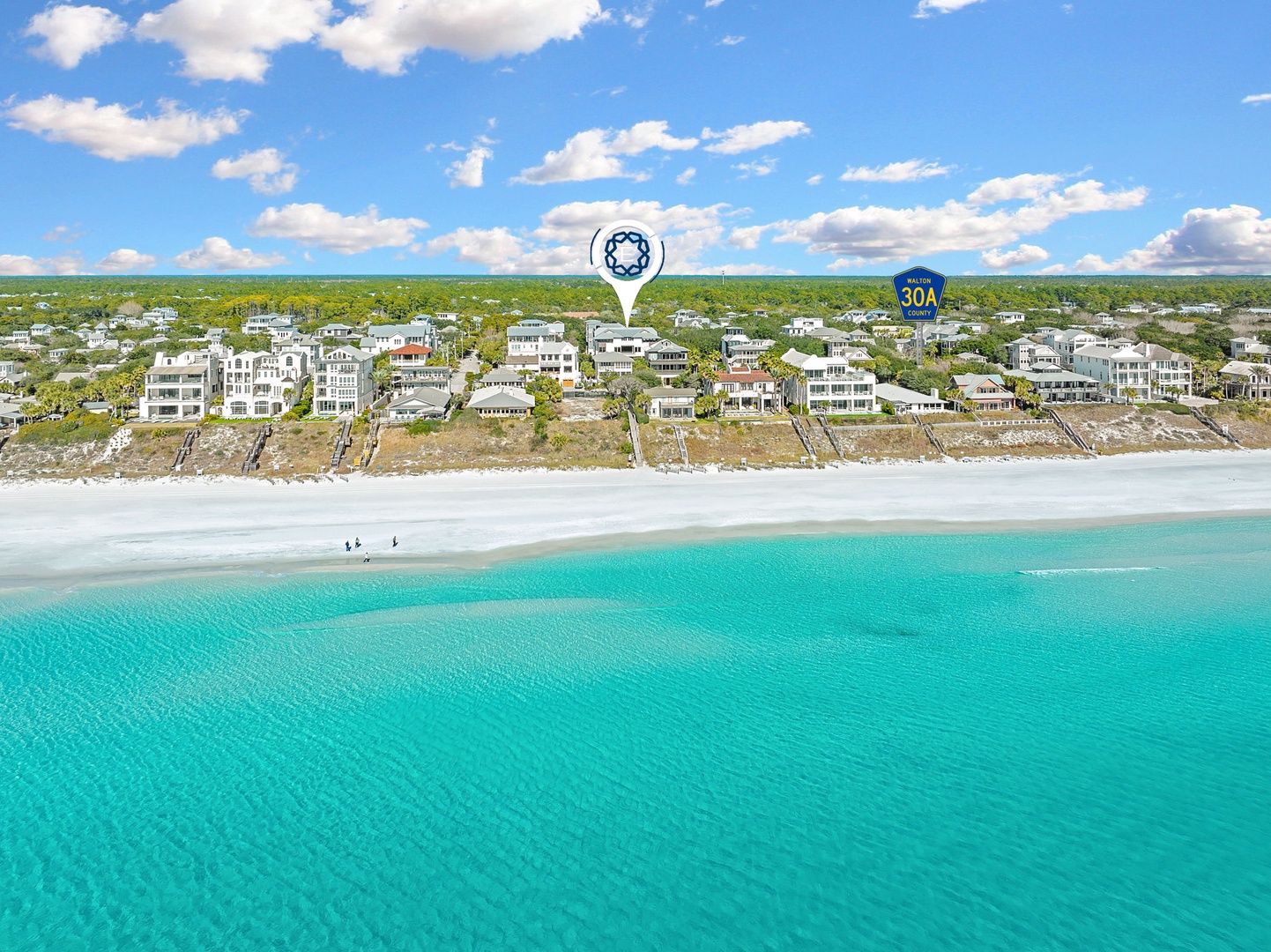 Stunning aerial view of pristine beachfront community with crystal-clear turquoise waters and white sandy shores.