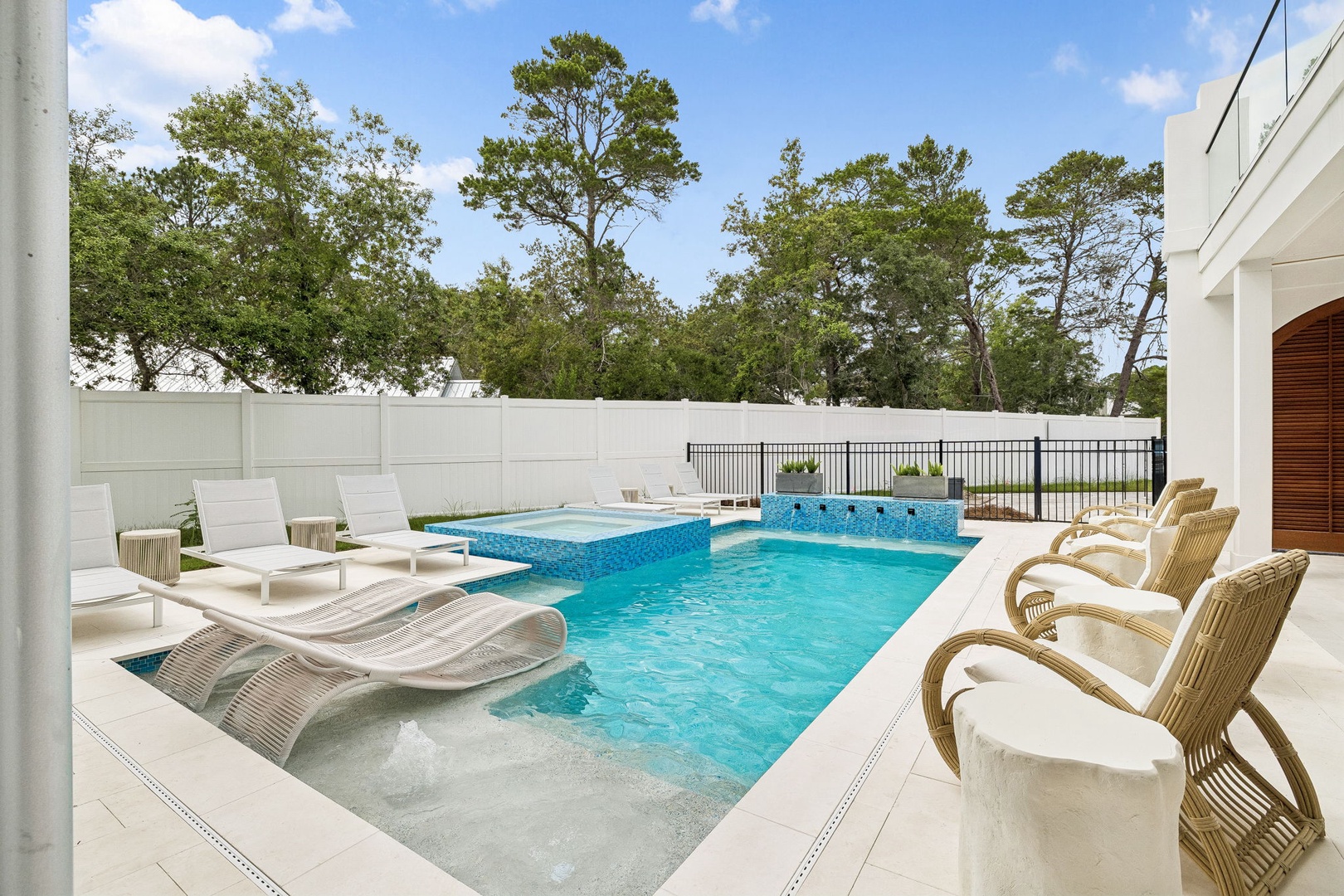 Your private oasis awaits with a sparkling pool, spa, sun-soaked loungers, and lush tree-lined views—perfect for poolside relaxation under the open sky.