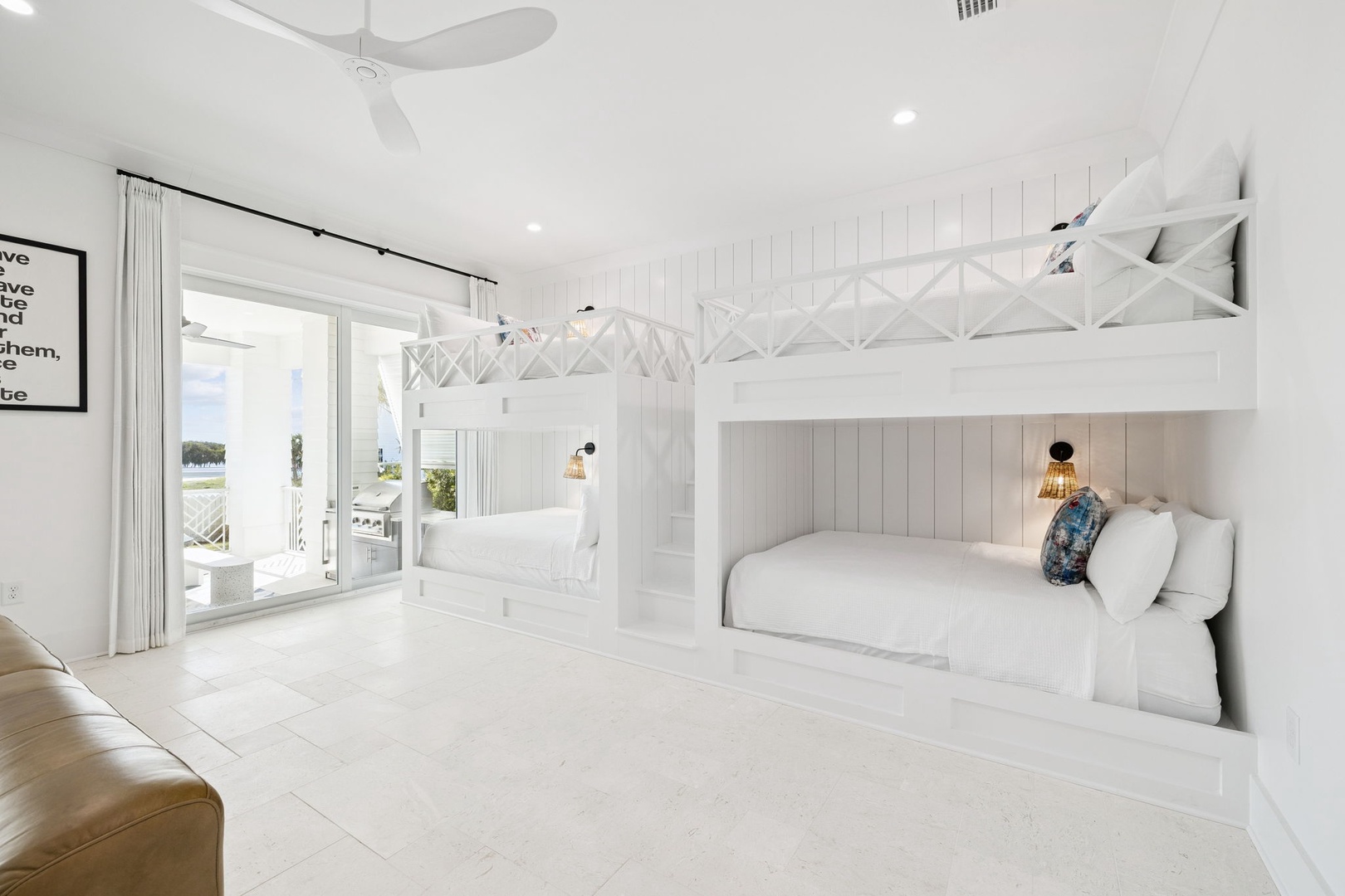 Rest peacefully in your bright coastal bedroom featuring custom bunk beds with crisp linens and ocean views through sliding doors.