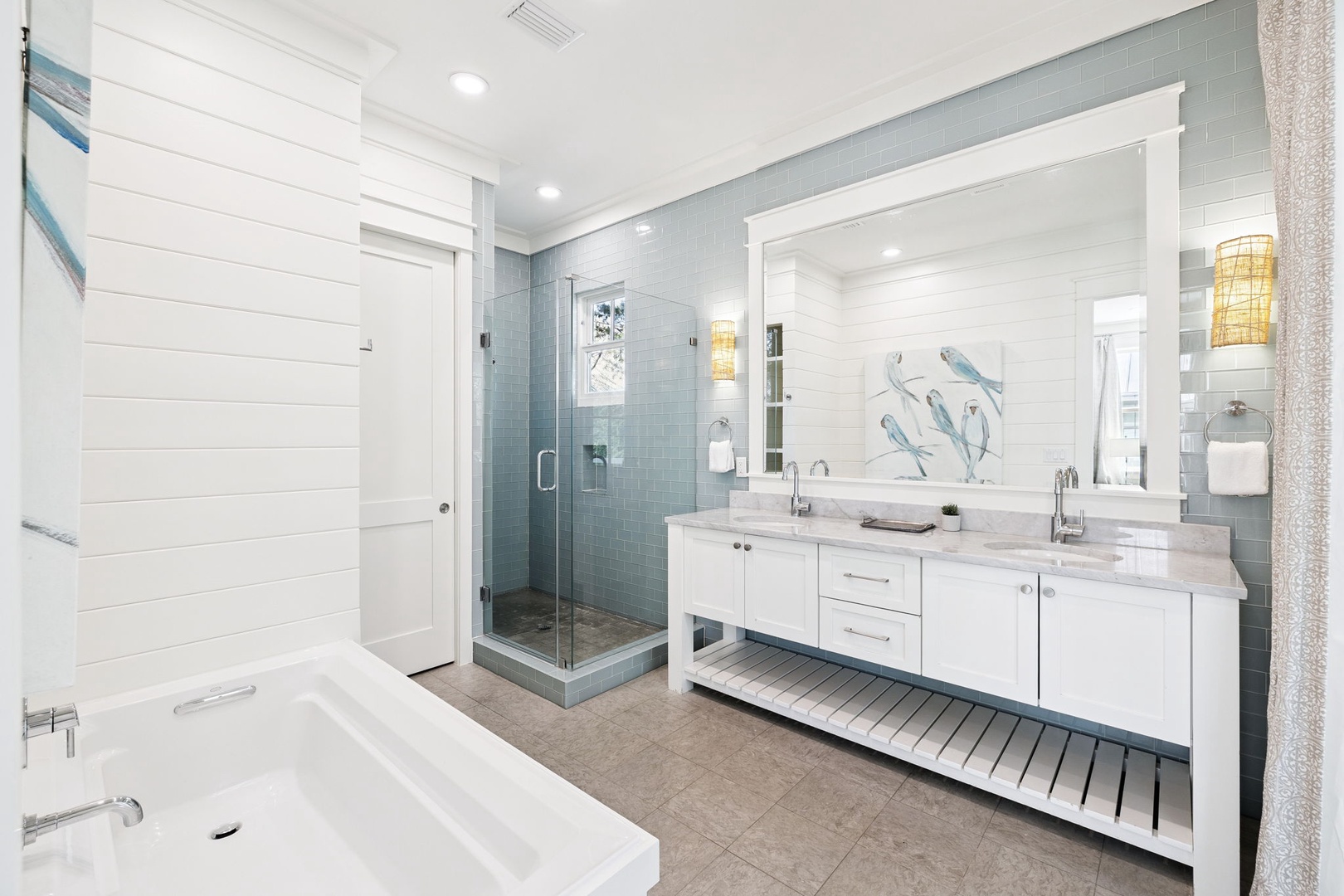 Unwind in your spa-like bathroom featuring dual vanities, marble countertops, a soaking tub, and glass shower.