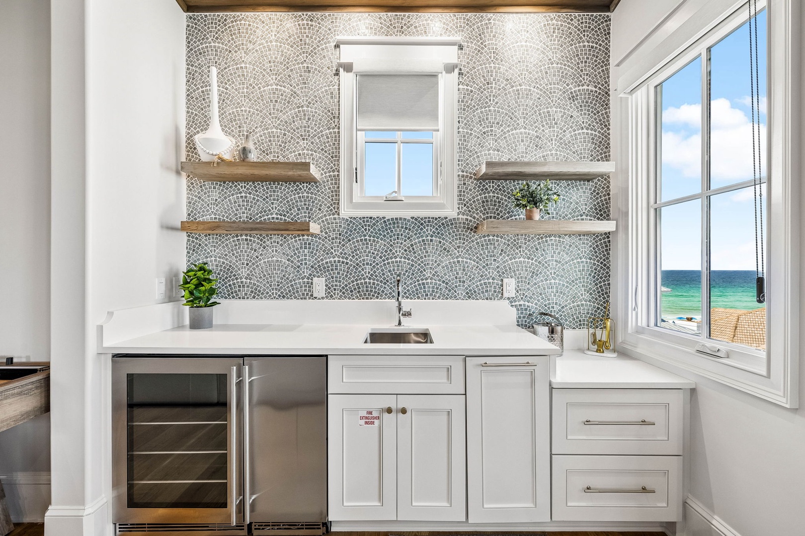 Your coastal kitchenette sparkles with designer mosaic tile, open shelving, and stunning ocean views right from the window. Prepare drinks while waves glisten outside.