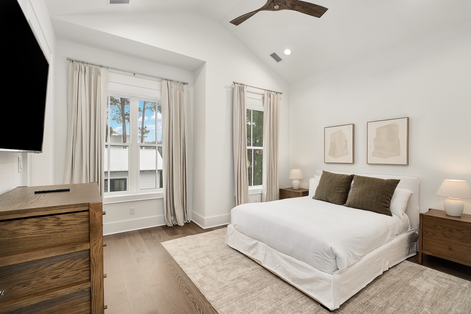 Sink into crisp white linens in your serene bedroom, where natural light flows through elegant windows and modern comforts await.