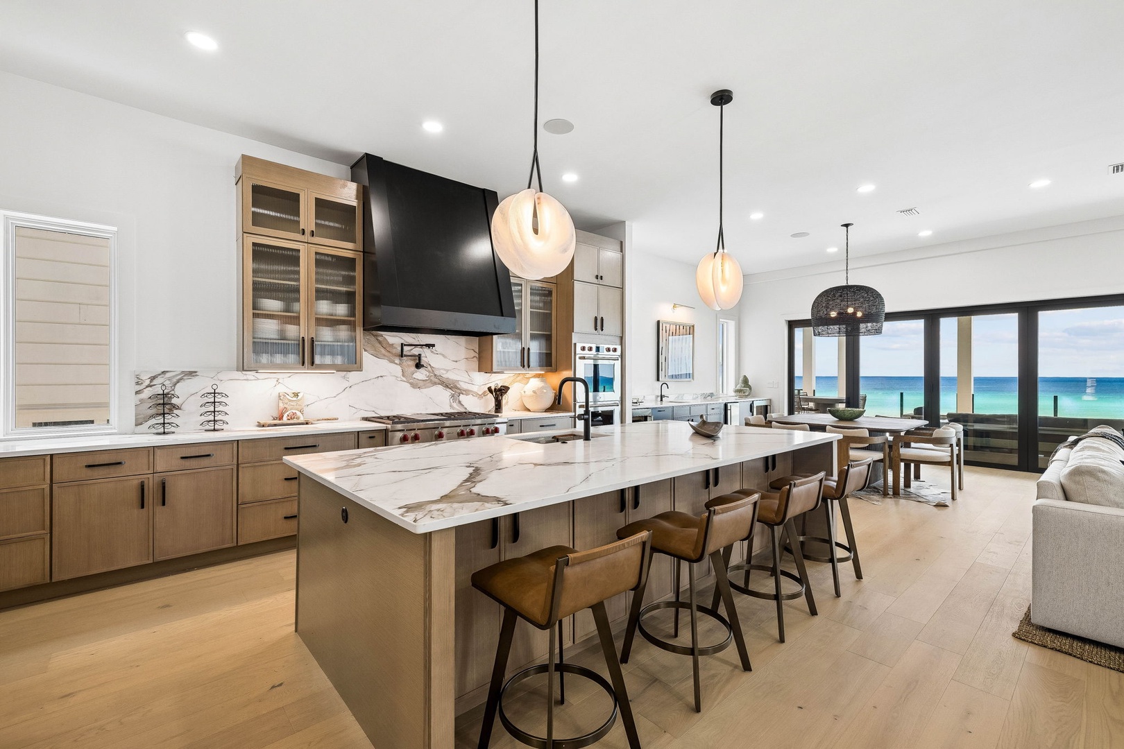 Gather around the stunning marble island where gourmet meals come to life, then look beyond to find turquoise waters framed by floor-to-ceiling windows—your perfect backdrop for morning coffee and evening cocktails.