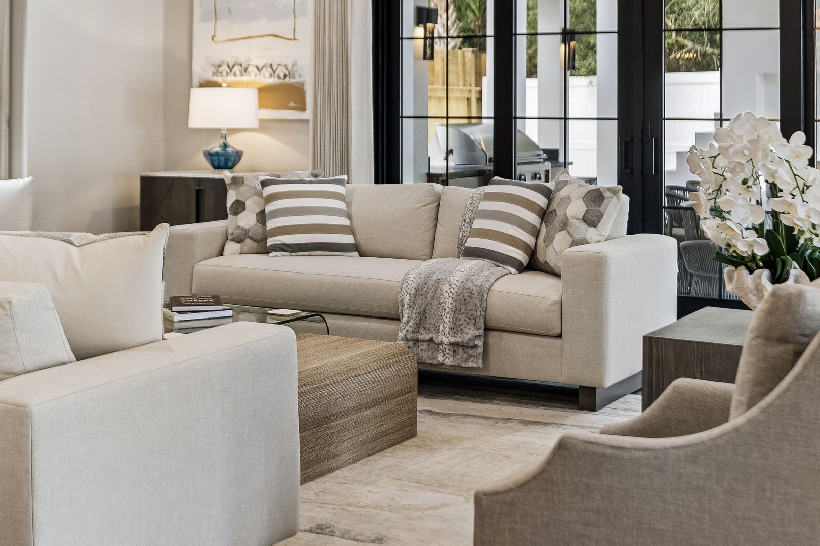 Unwind in your elegant living room where plush sofas, warm lighting, and tall glass doors create a serene space for your peaceful getaway.