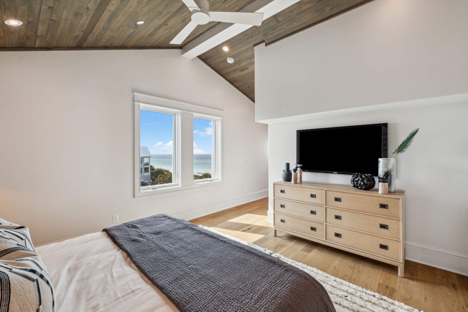 Wake up to breathtaking ocean views from your cozy bedroom, where wood-beam ceilings and coastal breezes create your perfect seaside escape.