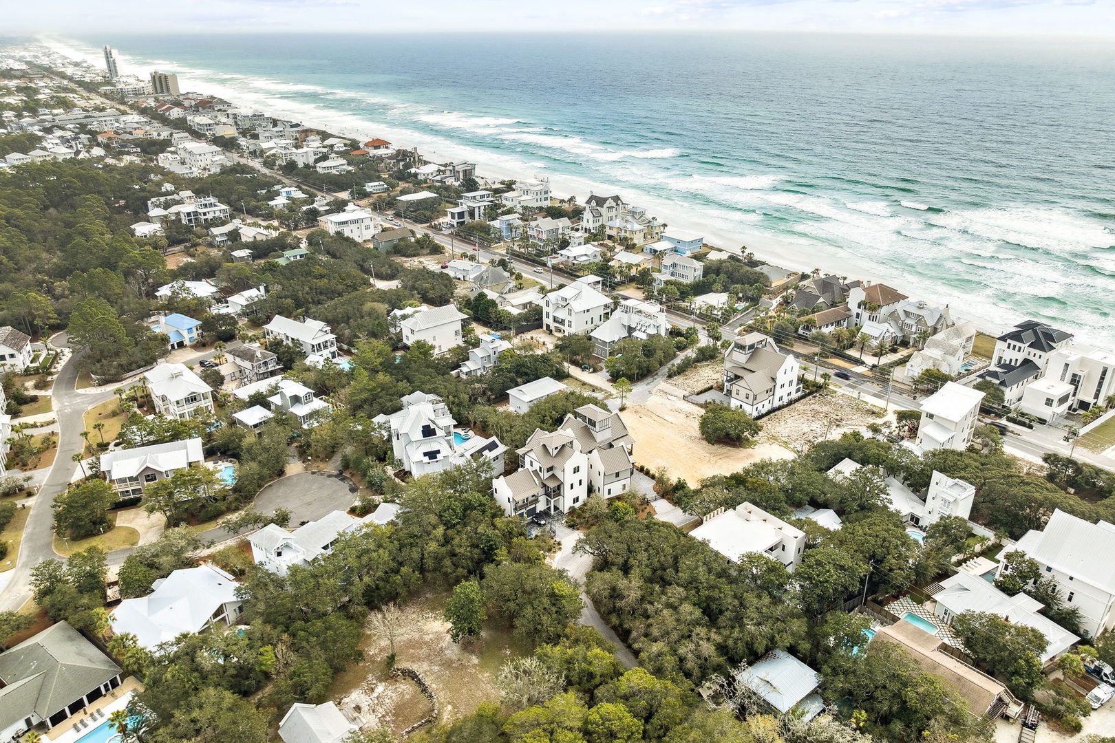 Stunning aerial view of a pristine beachfront community with white sand beaches and emerald Gulf waters stretching endlessly.