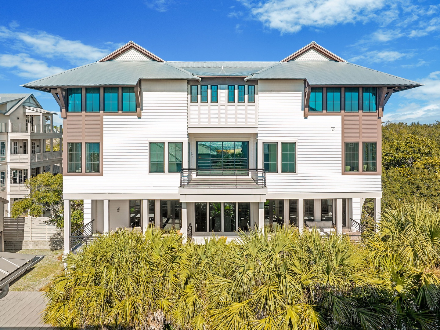 Modern coastal architecture with tropical landscaping creates an impressive arrival experience at this elevated beachside property.