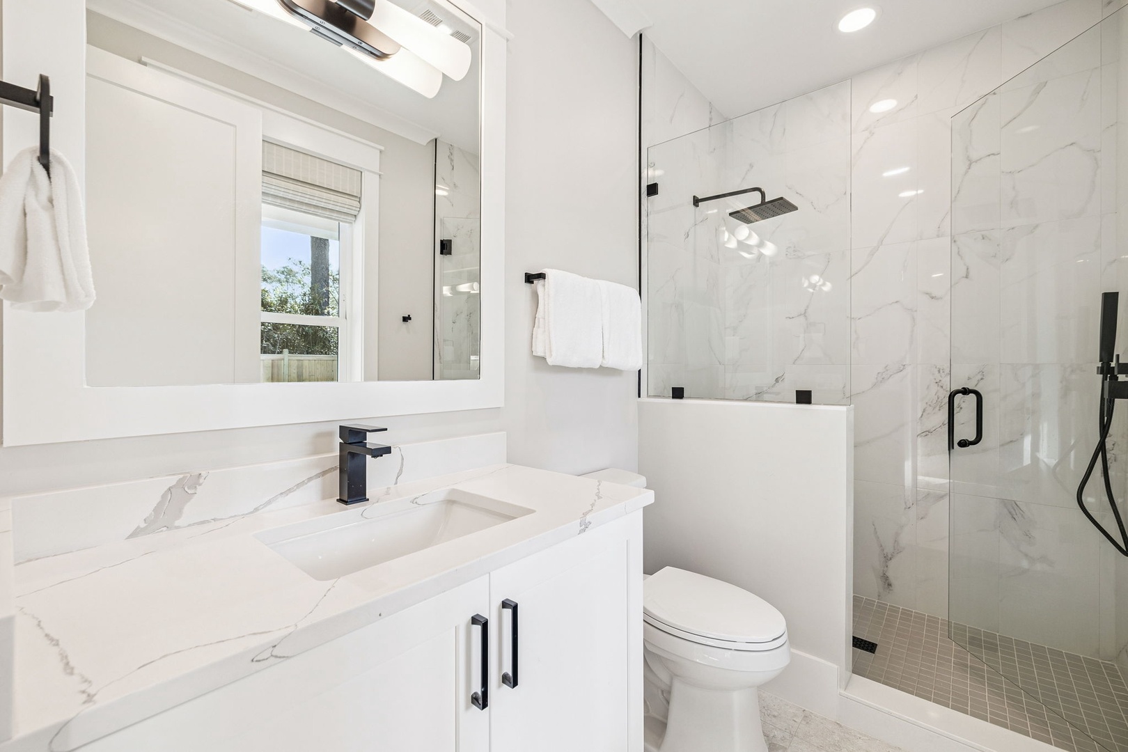 Step into your pristine marble sanctuary featuring a luxurious walk-in shower and elegant vanity where you'll start each morning refreshed.