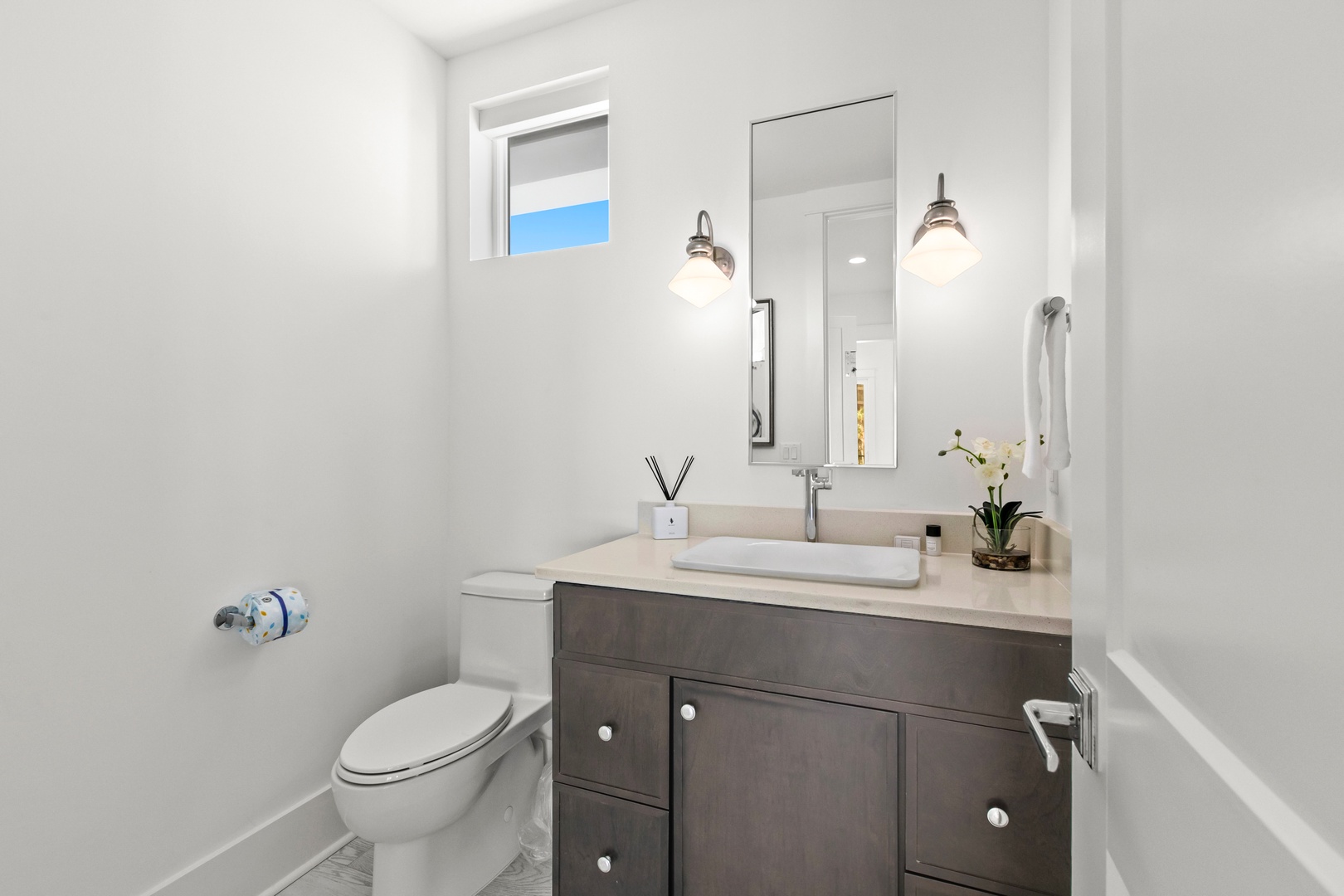 Fresh and spotless, your private bathroom features a modern vanity, bright lighting, and thoughtful touches like soft towels and fresh florals to make you feel right at home.