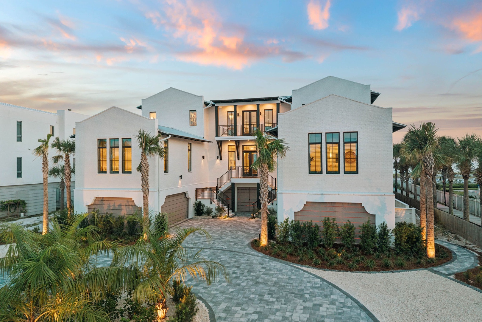 A stunning coastal retreat framed by palm trees at sunset, combining modern architecture with tropical charm in a peaceful waterfront neighborhood.