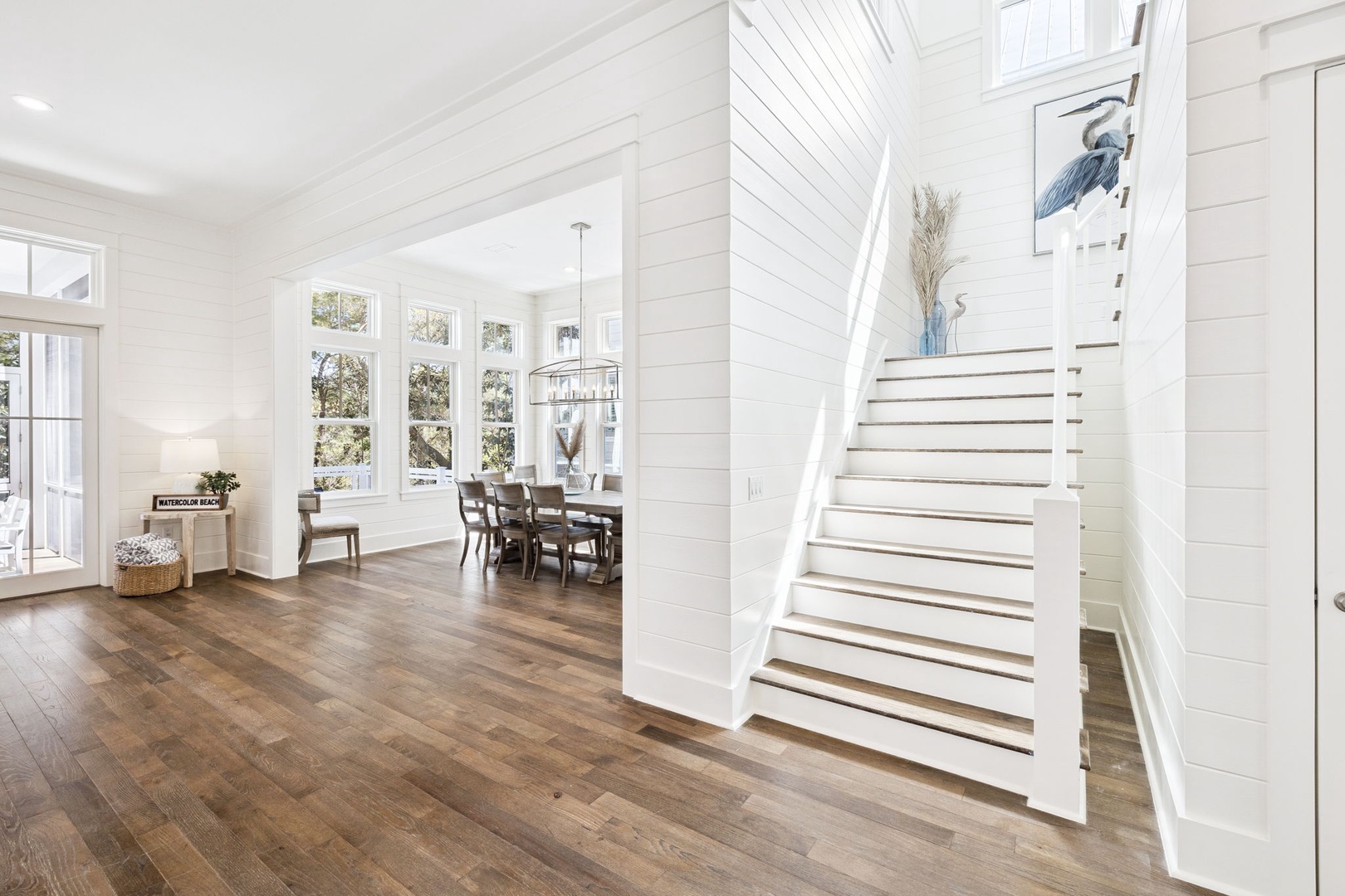 Step into this bright, airy space where white shiplap walls and rich hardwood floors create your perfect coastal retreat.