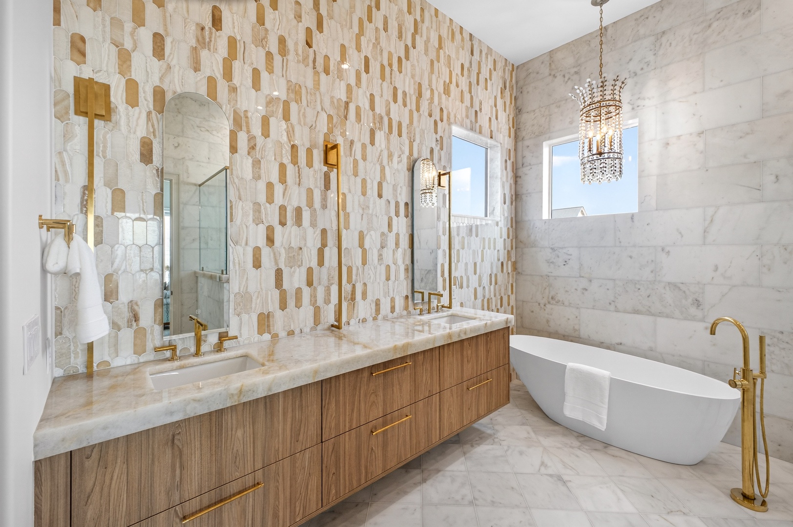 Soak away your worries in this luxurious marble bathroom featuring a stunning freestanding tub and elegant gold fixtures.