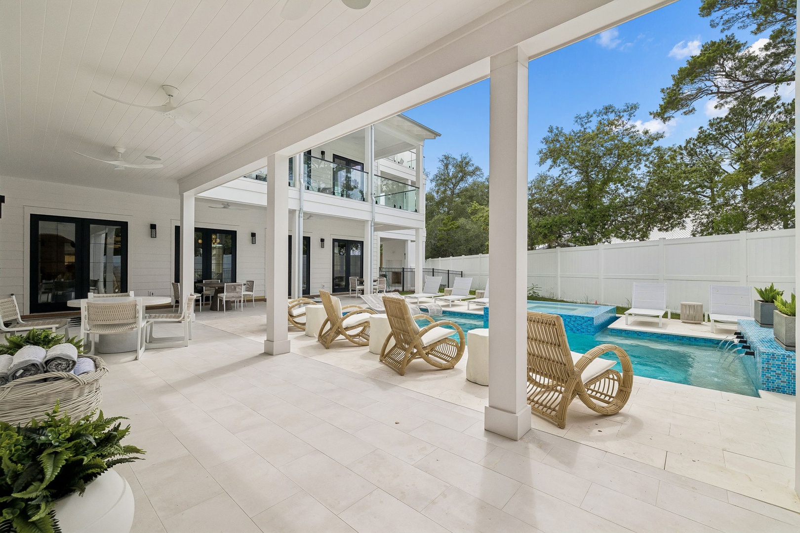 Step onto your private covered patio where coastal-inspired rocking chairs invite you to unwind beside the sparkling pool, seamlessly blending indoor comfort with outdoor elegance.