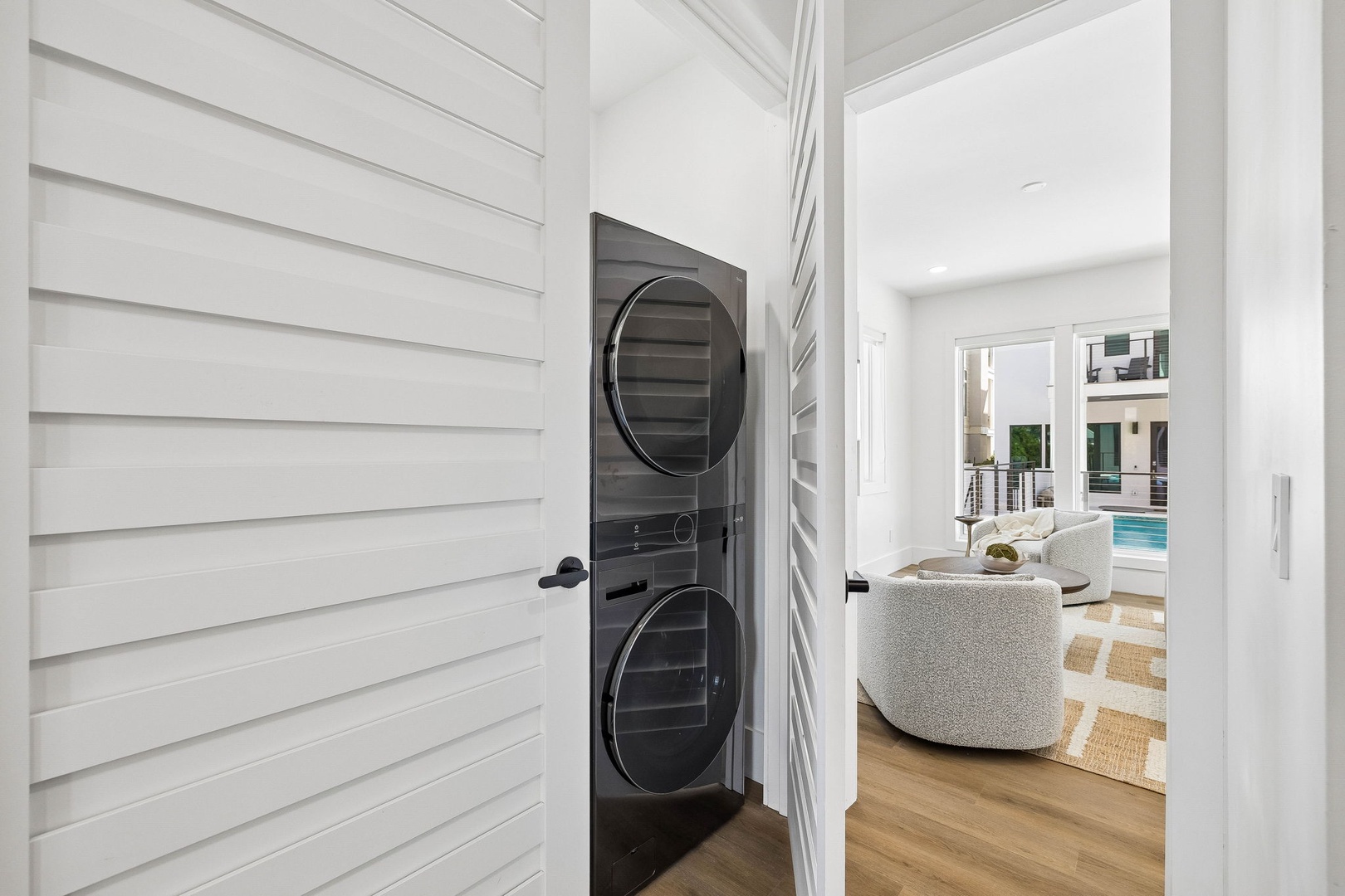 Your in-unit stacked washer and dryer nestles discreetly behind a sleek door, keeping laundry convenient while you enjoy the bright, open living space just beyond.