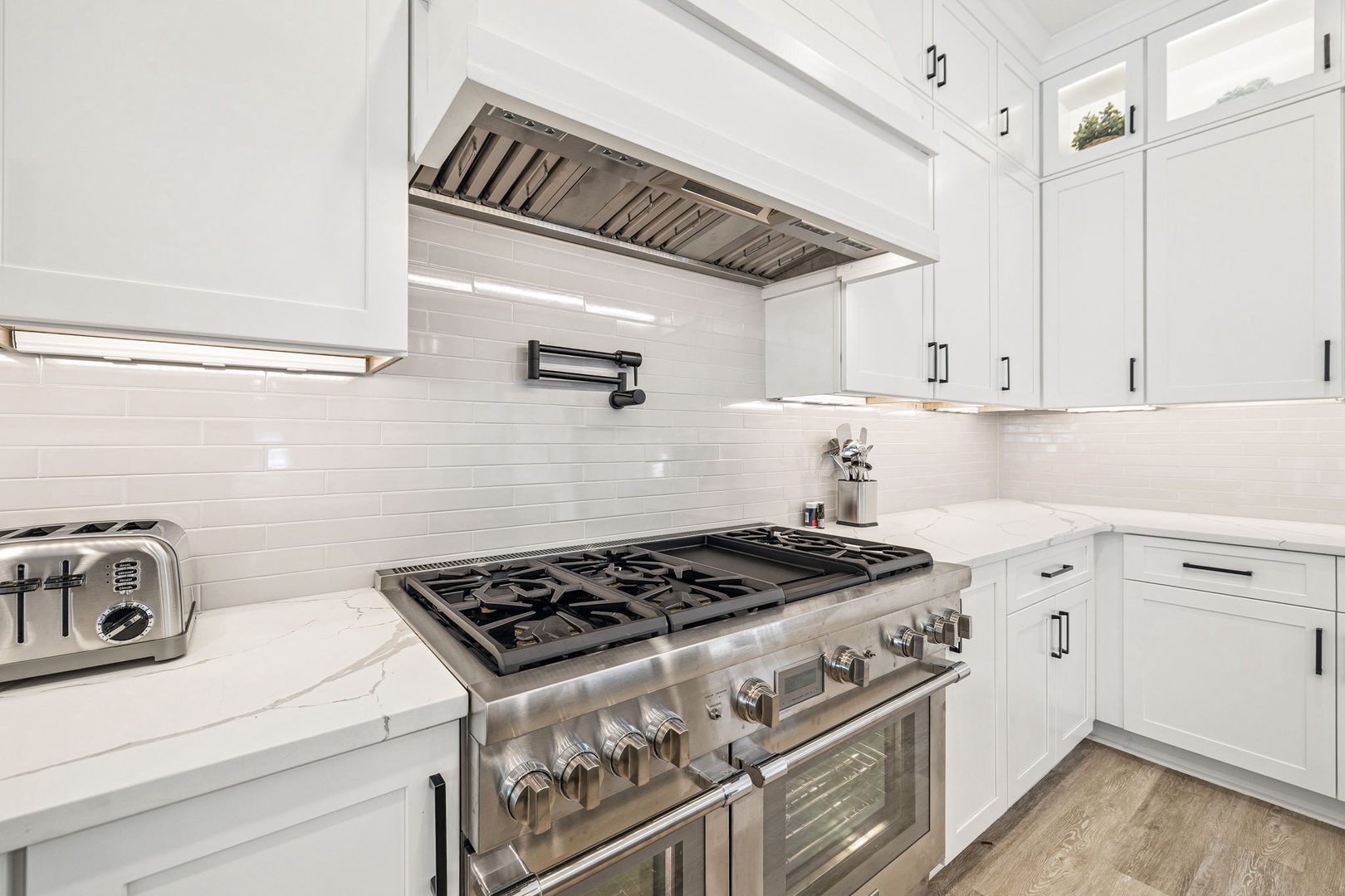 Your sleek, modern kitchen features professional-grade appliances and pristine white cabinetry, perfect for preparing memorable meals during your stay.