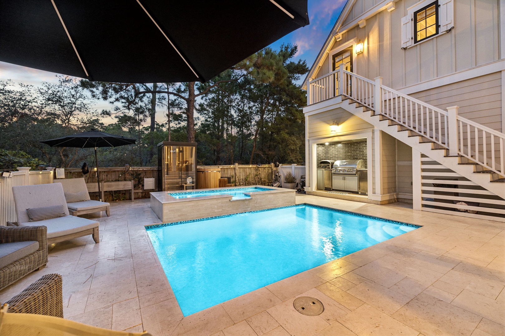 This stunning beach-style retreat invites you to unwind by your private pool as evening lights glow warmly around you. Swim, lounge, or gather with loved ones in this elegant outdoor oasis.