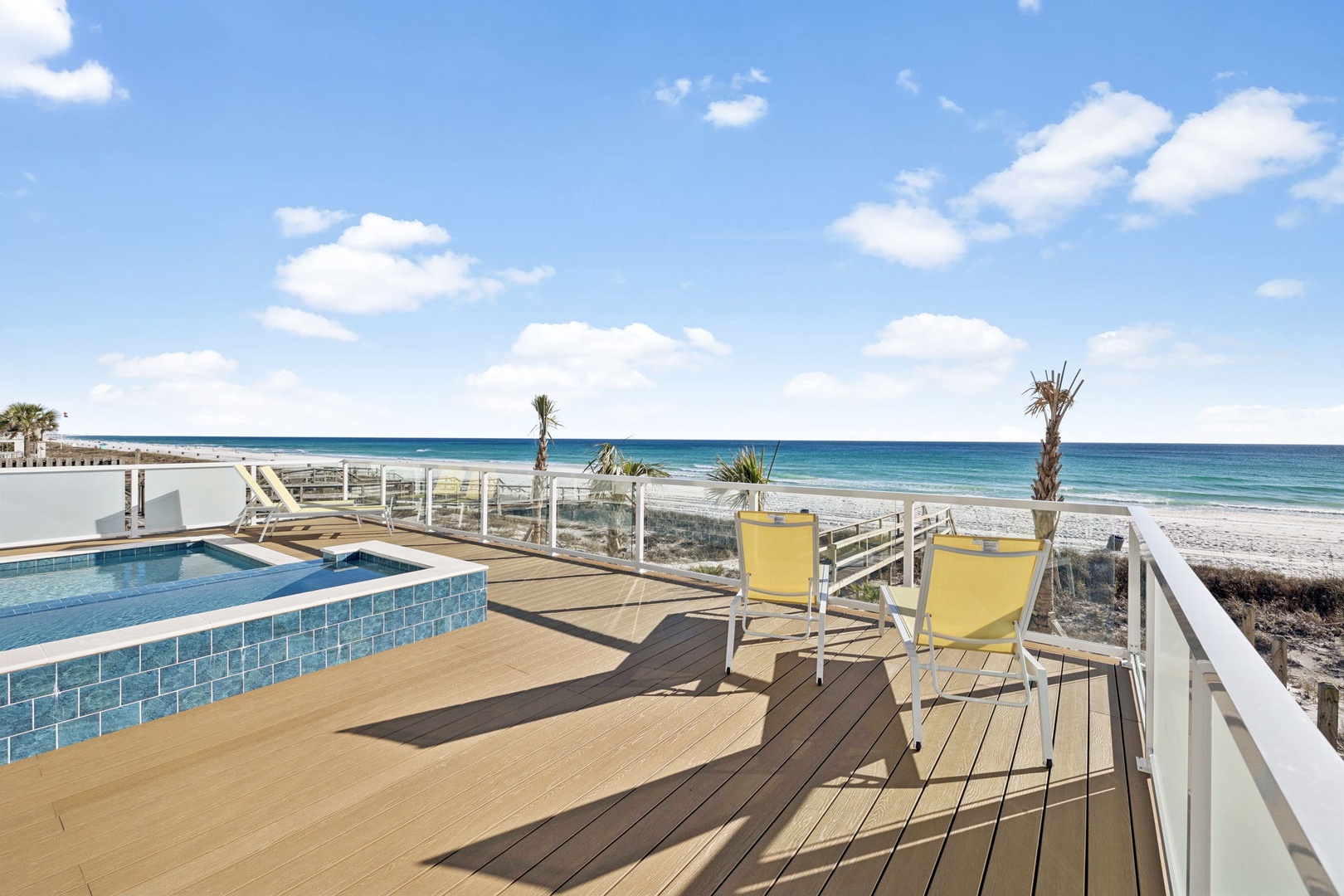 Unwind on your private deck with stunning ocean views, where turquoise waters meet pristine sands just steps from your poolside retreat.