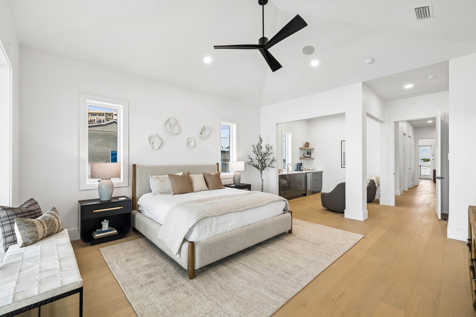 Your spacious bedroom welcomes you with plush neutral tones, a ceiling fan for comfort, and warm wood floors underfoot—a perfect retreat to unwind after exploring the area.