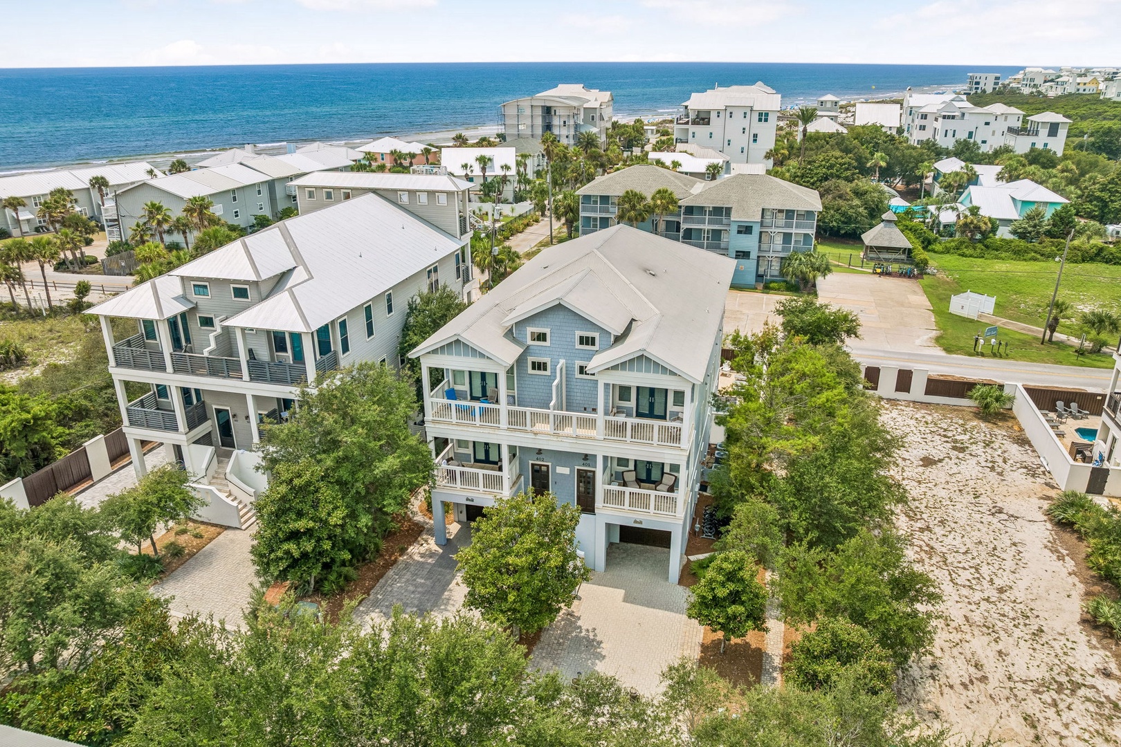Coastal retreat nestled among palms and lush greenery, just steps from pristine sandy shores and sparkling turquoise waters.