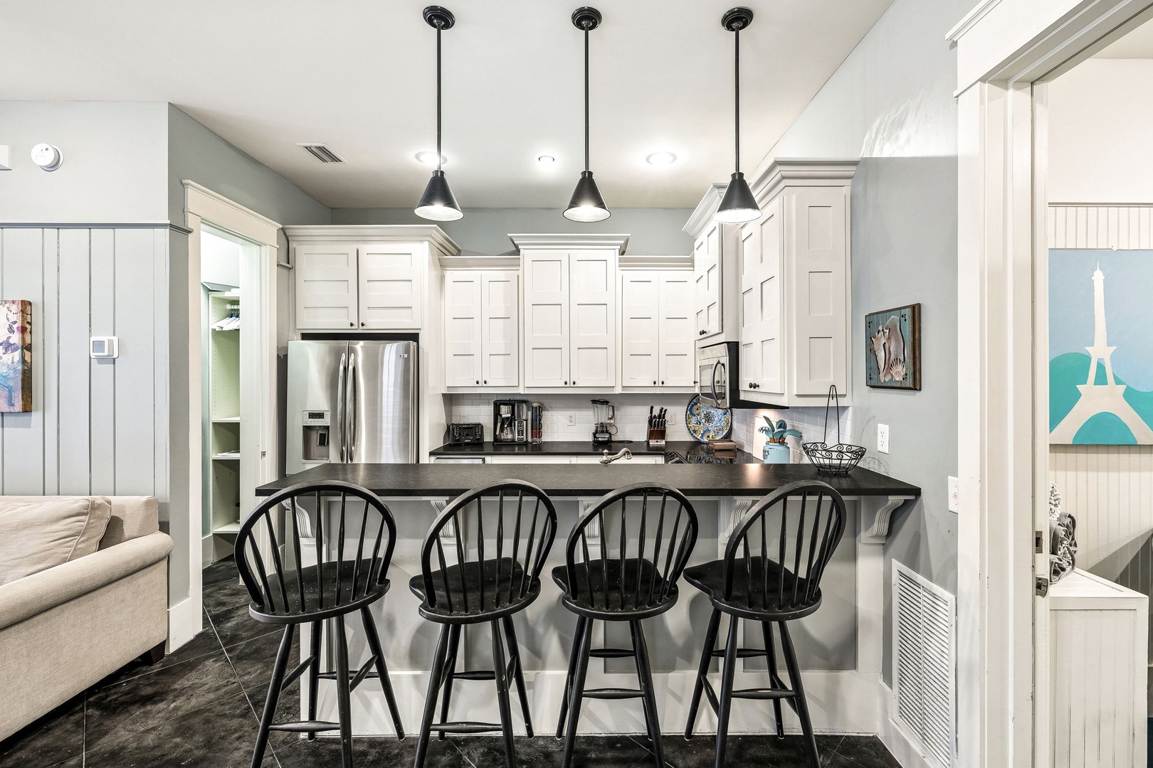 Gather around your spacious kitchen island with seating for four, where sleek pendant lights and modern appliances make meal prep a pleasure. The bright white cabinetry and open layout invite you to cook, chat, and create memories together.