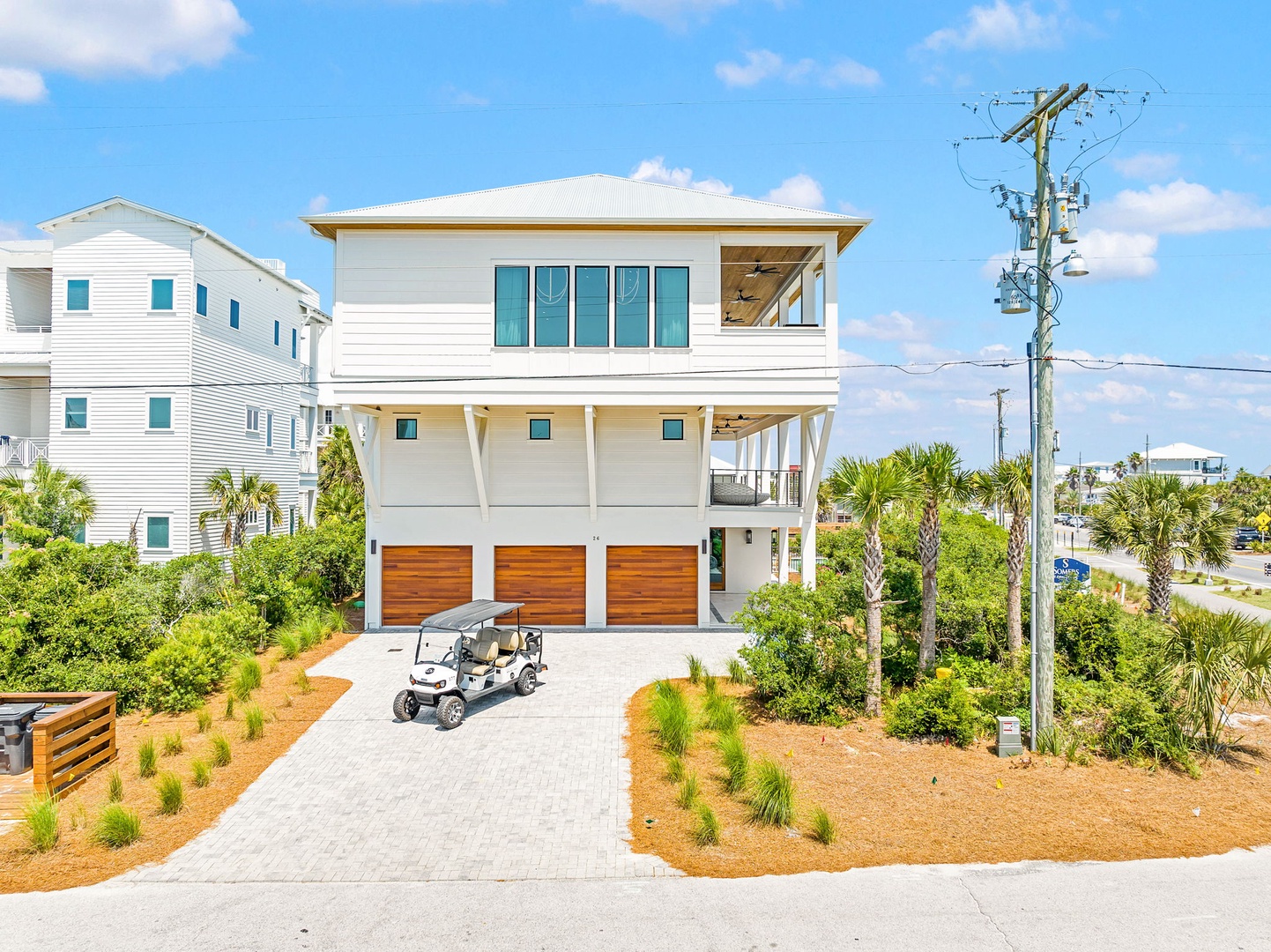 This modern coastal home features elevated architecture with ample parking and tropical landscaping in a quiet beach neighborhood.