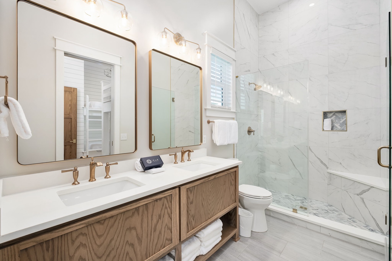 Indulge in your private spa retreat with luxurious marble shower, double vanity, and elegant gold fixtures for ultimate relaxation.
