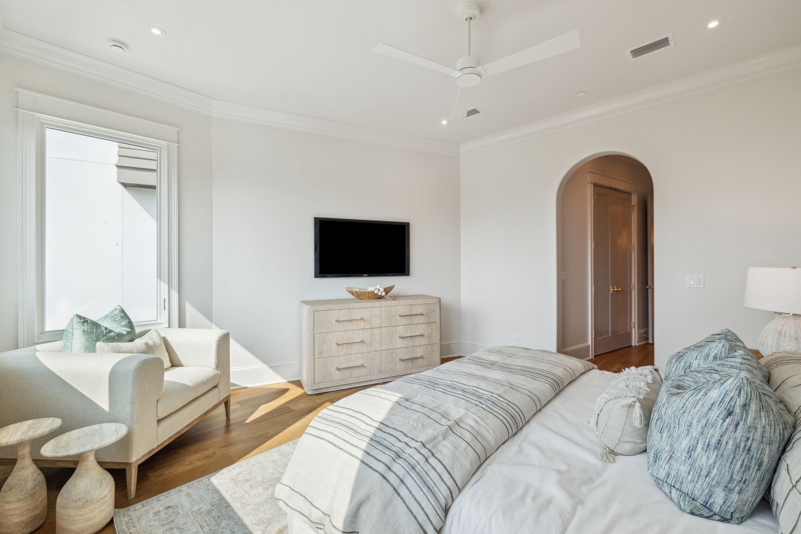 Sink into plush comfort in your serene suite, where soft linens, coastal-hued pillows, and sunlit warmth invite peaceful mornings and restful nights.