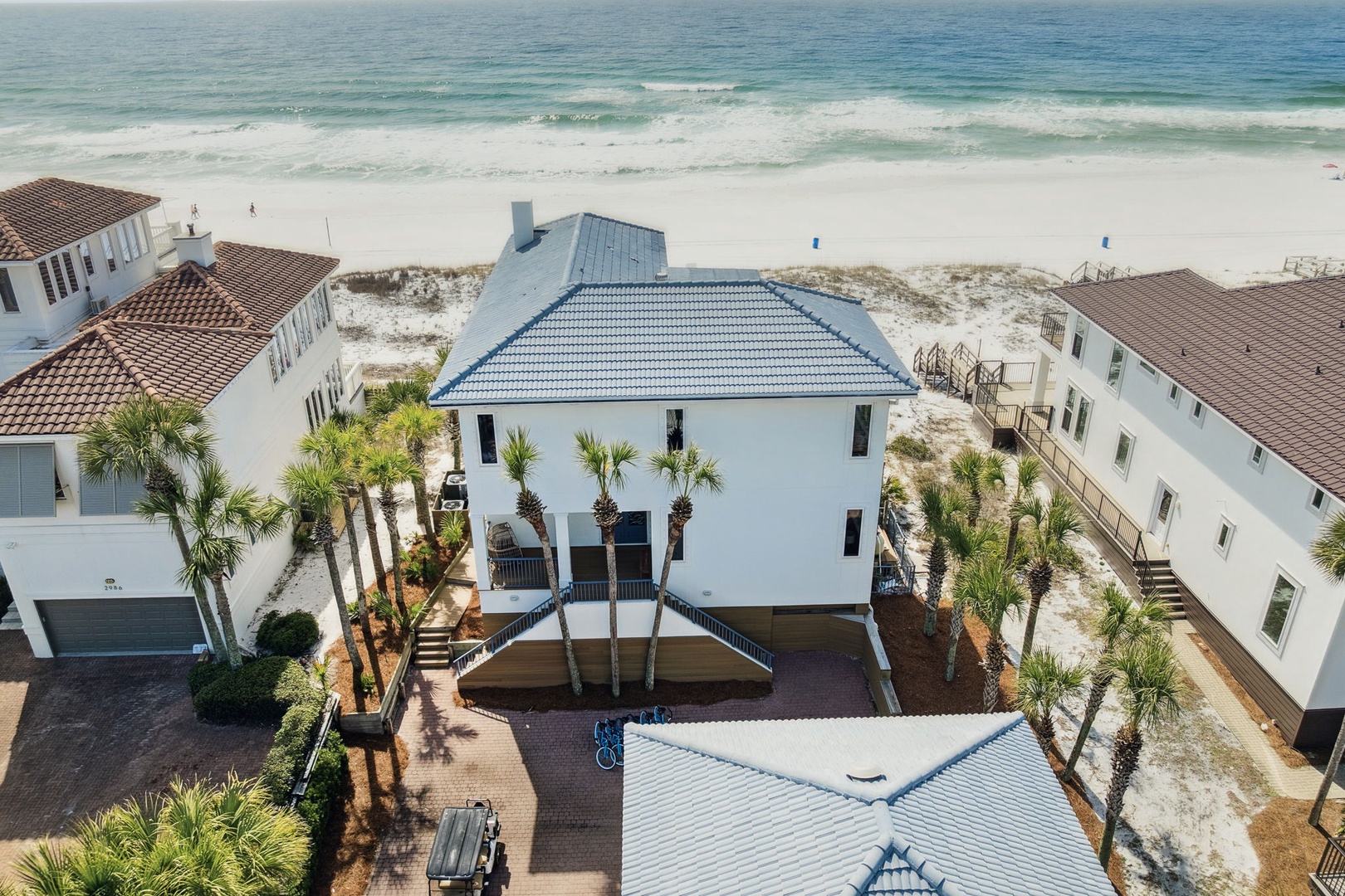 Coastal property featuring elevated design and beachfront location with pristine white sand and turquoise waters.