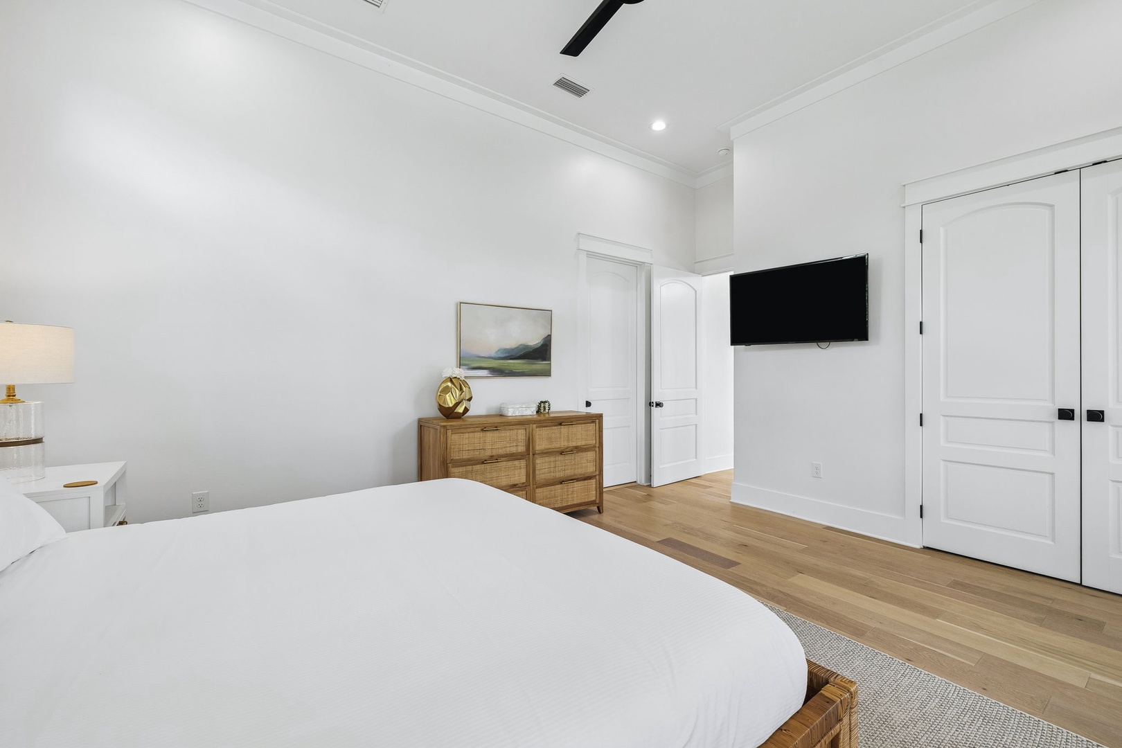 Relax in your serene bedroom, where crisp white linens and warm wood tones create a peaceful retreat. Stretch out after a day exploring and unwind with your favorite show on the wall-mounted TV.