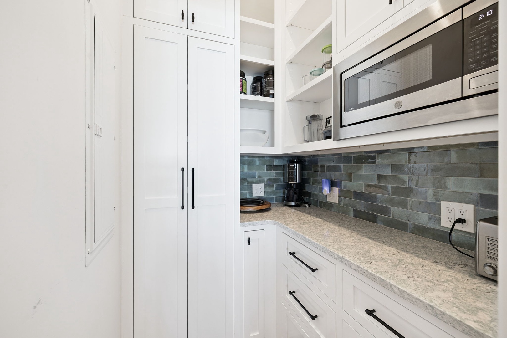 Your modern galley kitchen features sleek white cabinetry, granite counters, and stylish subway tile backsplash for effortless meal prep.
