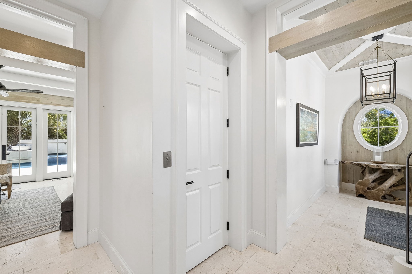 Step into this bright, airy entryway with soaring ceilings and natural light pouring through elegant windows, inviting you to discover your serene coastal escape.