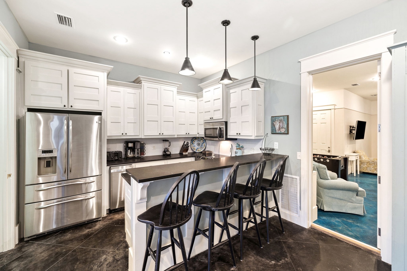 Gather around the bright kitchen island, perfect for casual meals or morning coffee together. Clean white cabinetry and modern appliances make meal prep a breeze during your stay.
