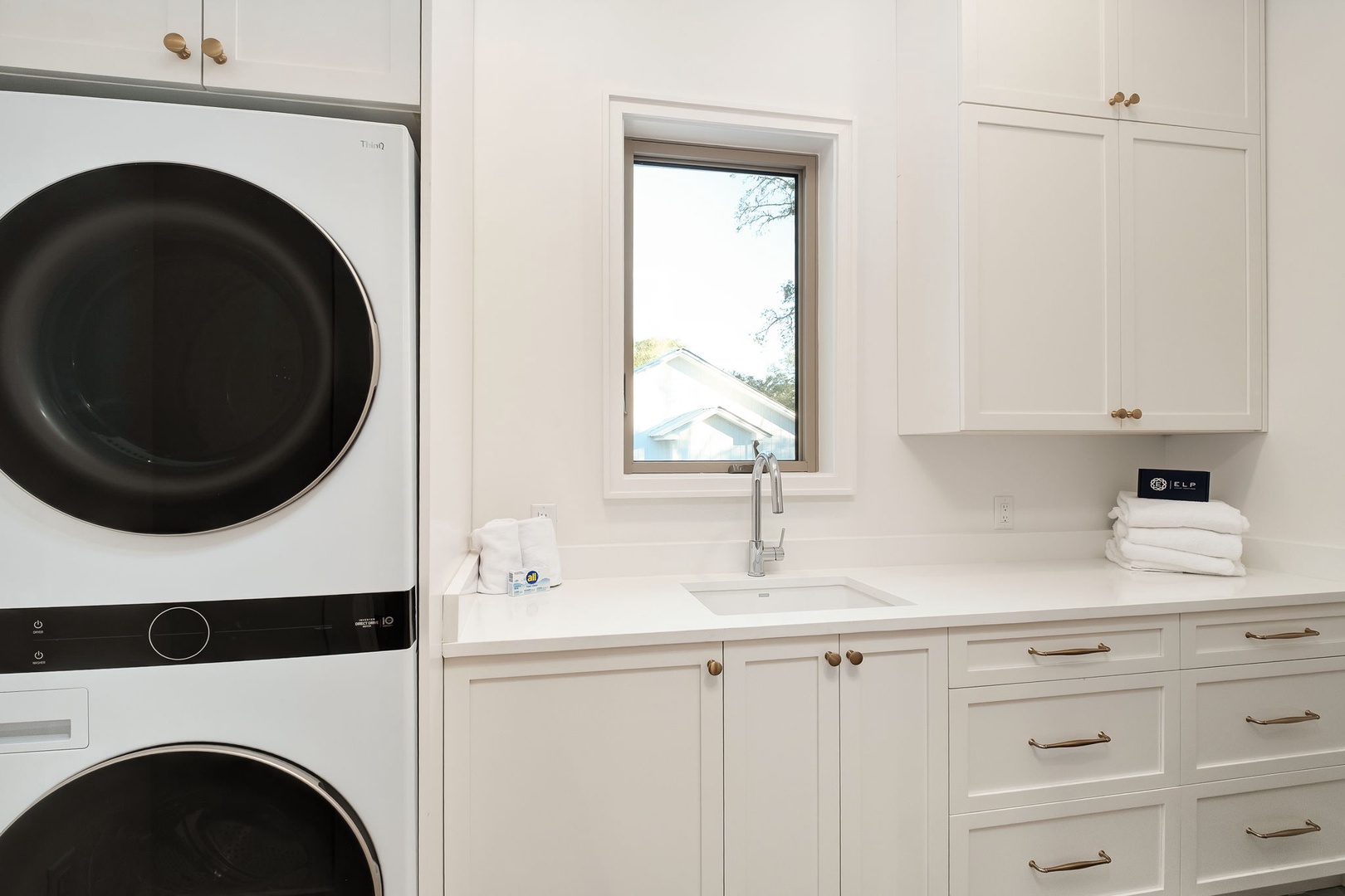 Your spacious laundry room features premium stacked washer-dryer, deep utility sink, and ample cabinet storage for effortless care of linens.