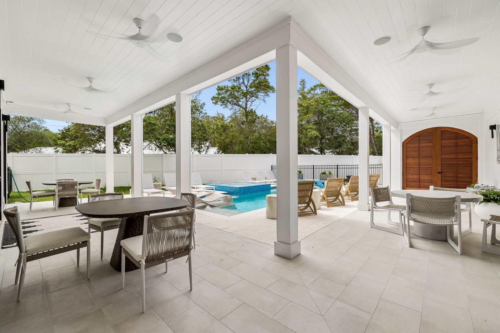 Picture yourself dining al fresco under soaring ceilings with cooling fans above, overlooking your private pool. This elegant covered patio offers the perfect blend of indoor comfort and outdoor leisure.