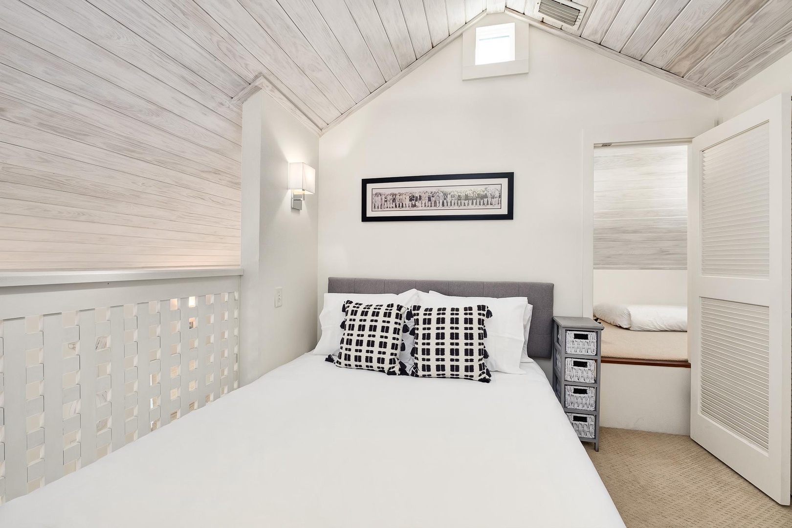 Drift off in your cozy white-washed bedroom, where crisp linens and rustic wood beams create the perfect seaside sanctuary for restful nights.
