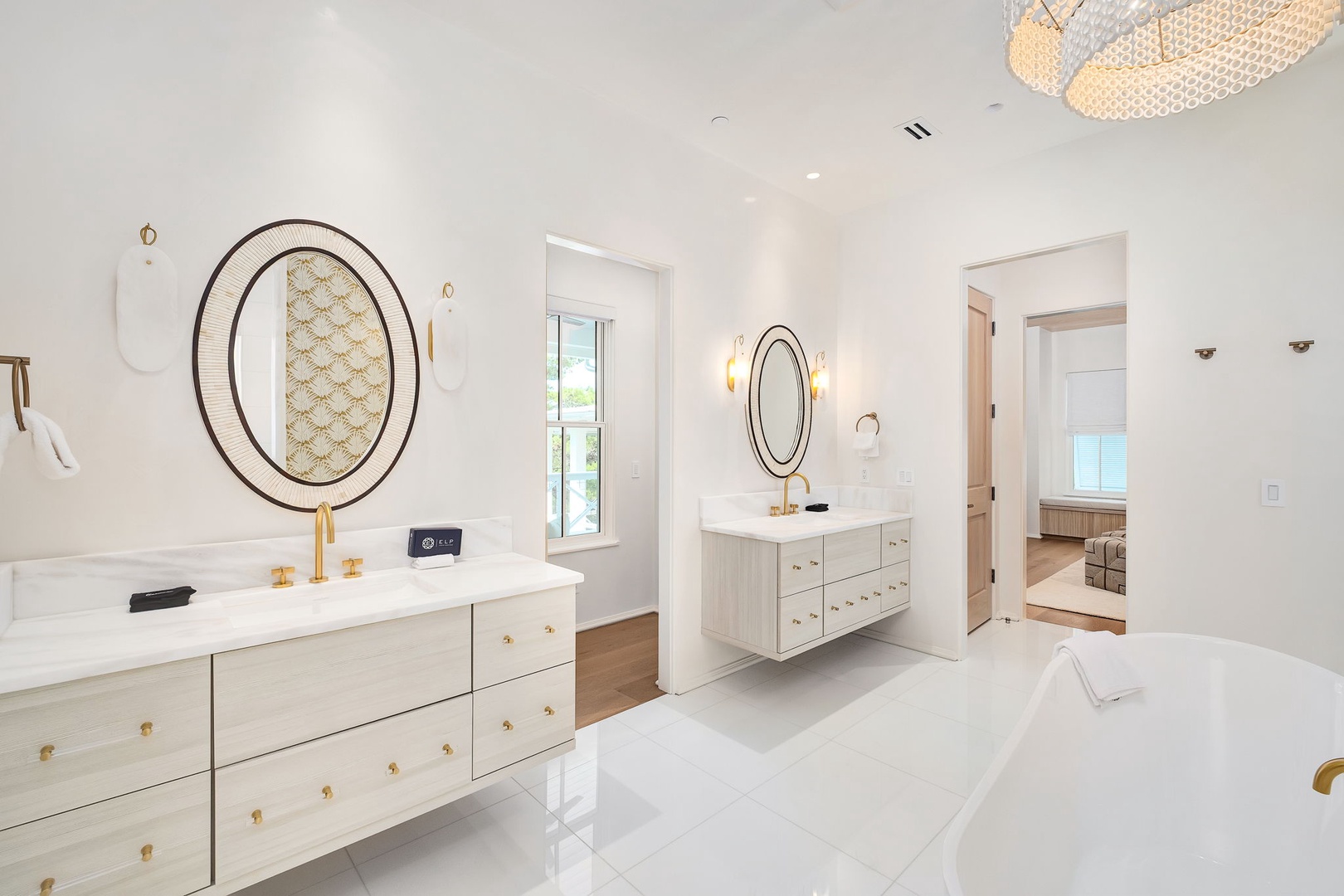 Luxurious dual vanities and a pristine soaking tub await you in this spa-like retreat, where elegant gold accents and designer lighting create your perfect sanctuary.