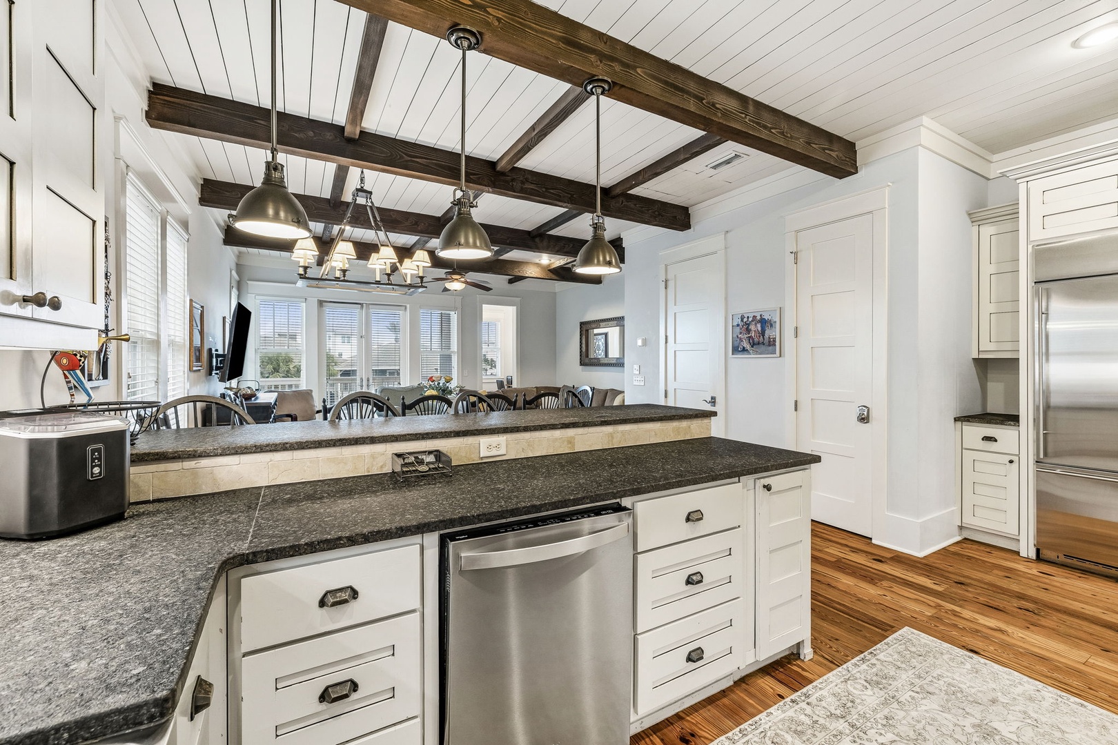 Step into your gourmet kitchen where rustic wood beams meet modern luxury. The spacious granite island invites you to gather, cook, and create memories beneath charming pendant lights.
