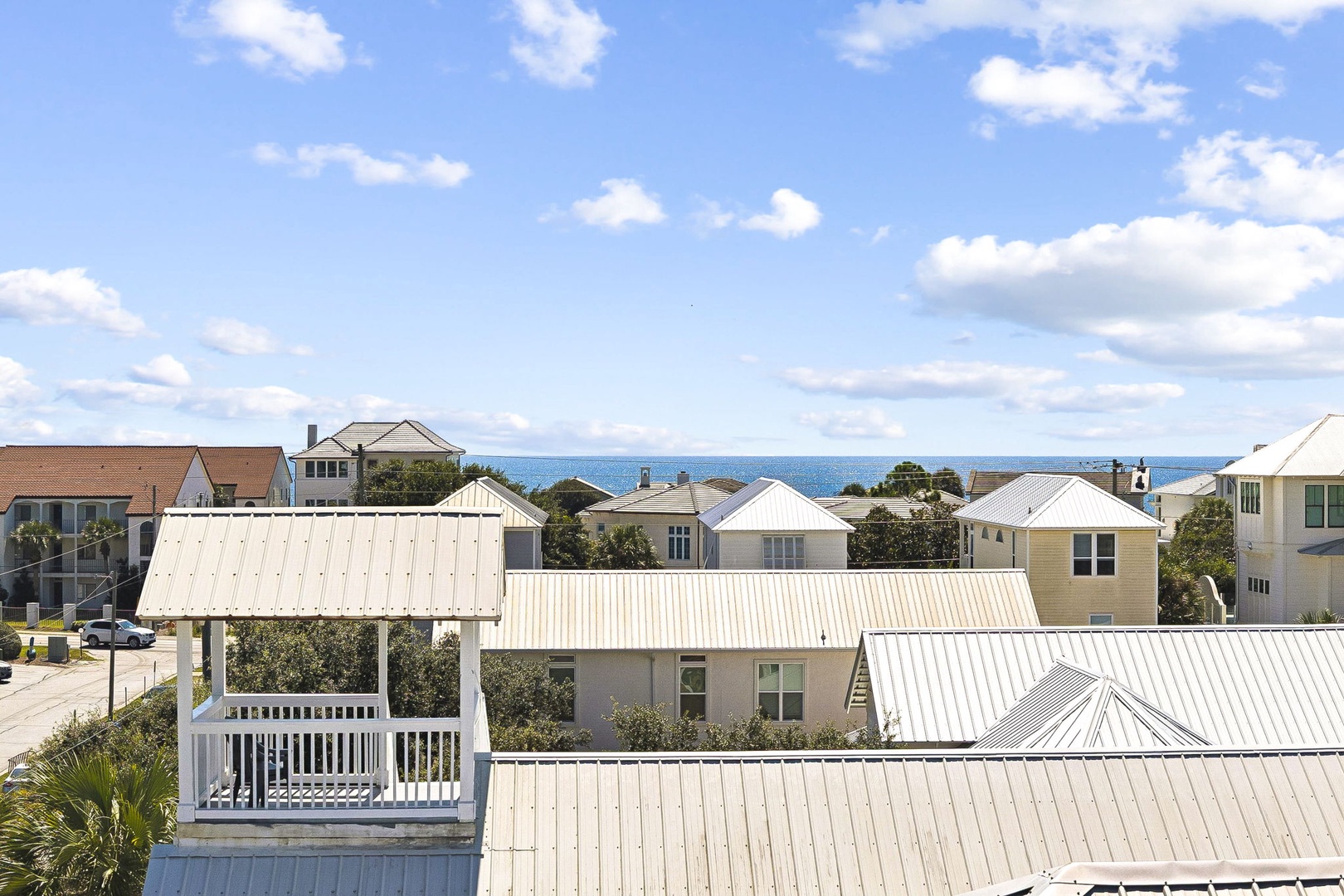 Coastal neighborhood featuring metal-roofed homes and ocean views visible in the distance, offering a serene seaside setting for your stay.