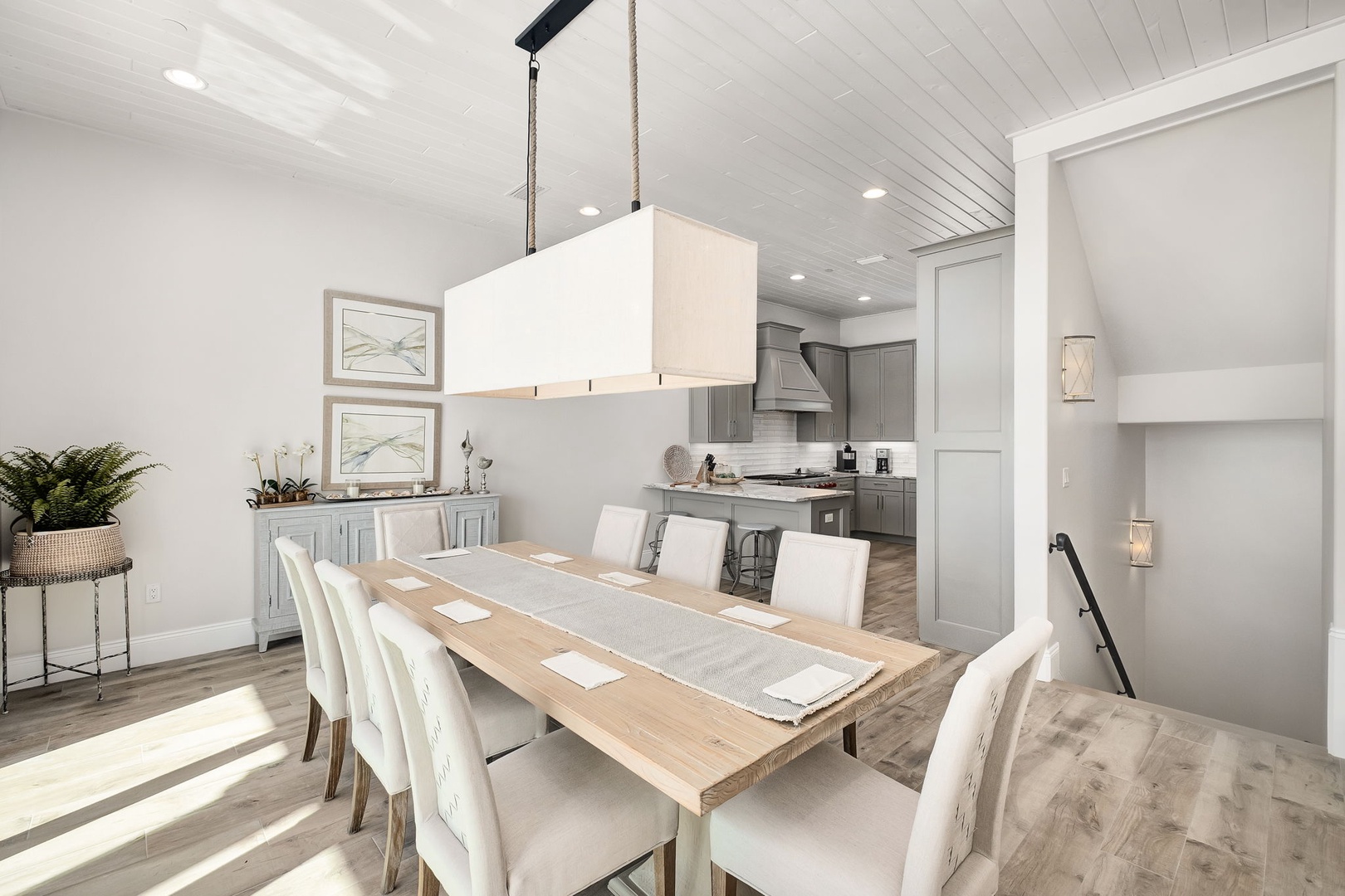 Gather around your elegant dining table where warm wood meets crisp white in perfect harmony, creating the ideal space for memorable meals.