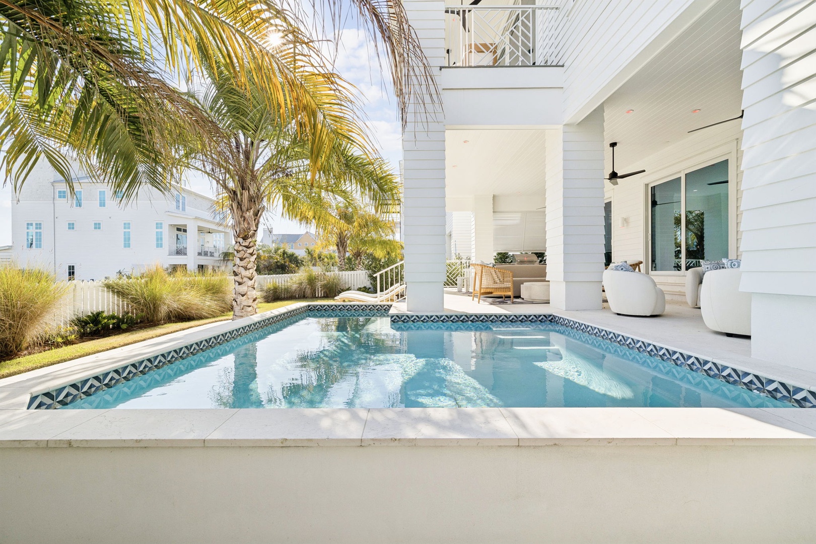 Your private pool oasis awaits, framed by swaying palms and elegant covered seating where you can unwind in tropical luxury.